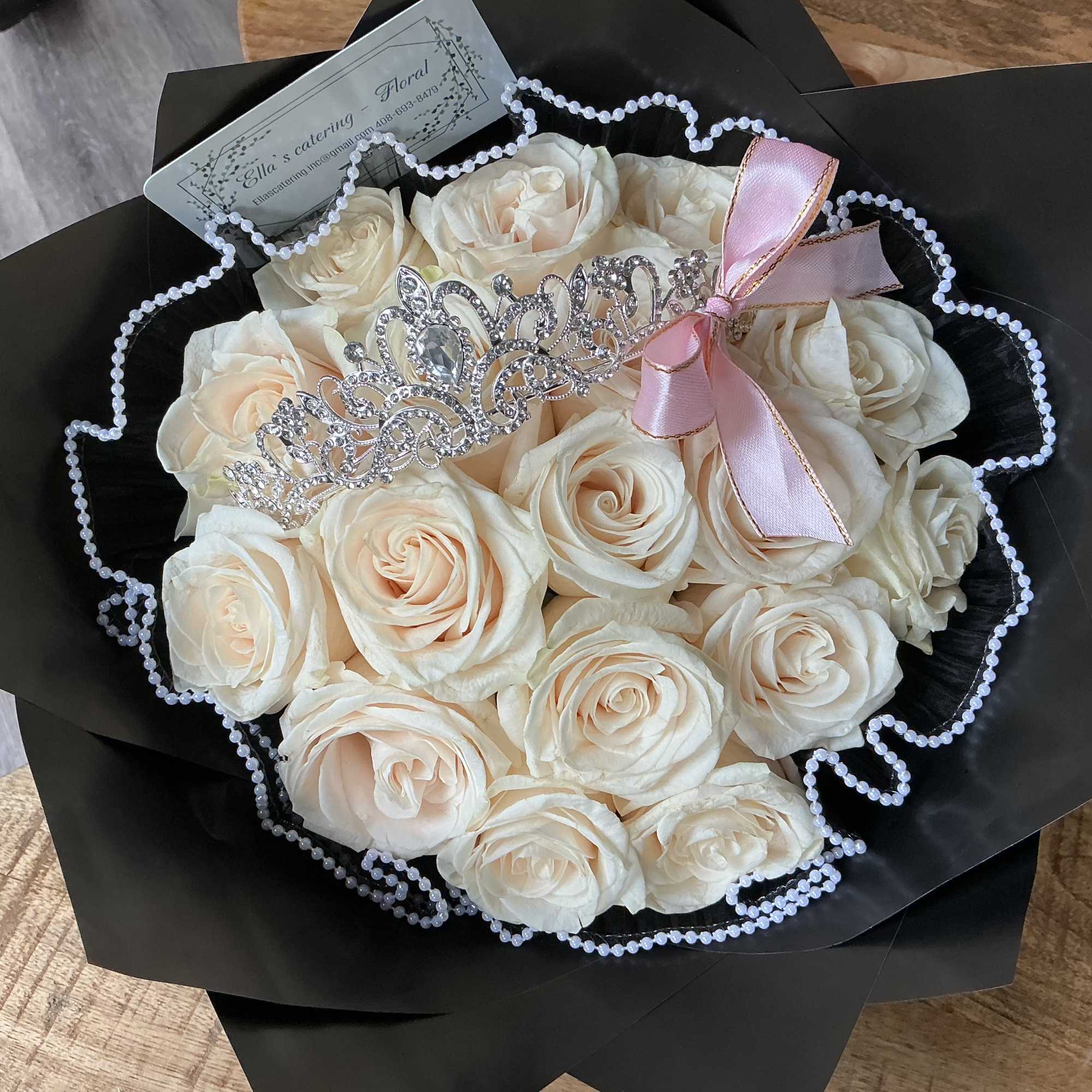 Bouquet of cream roses with a jeweled tiara and pink ribbon