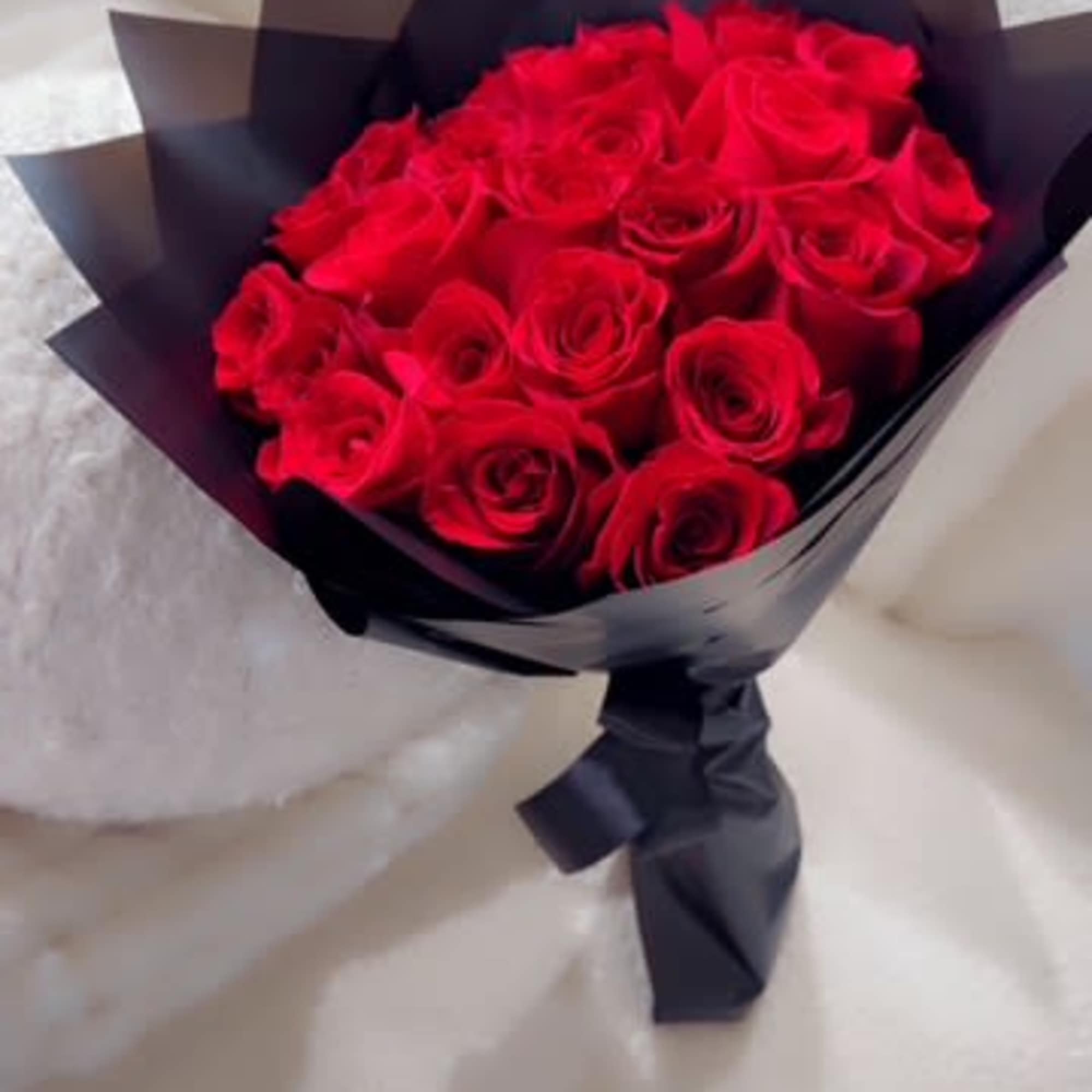 Bouquet of red roses wrapped in black paper