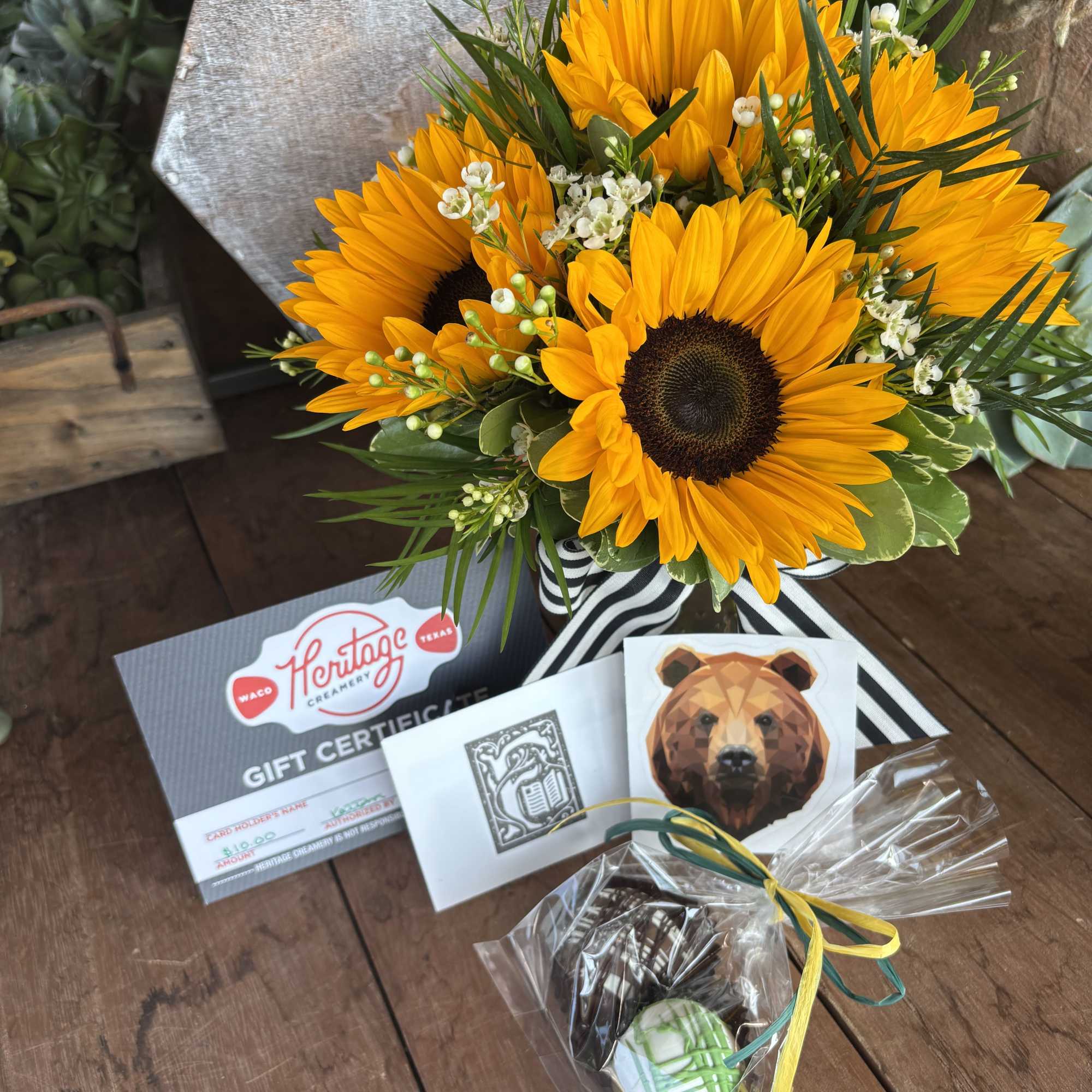 Bouquet of bright sunflowers with small white filler flowers and gift items