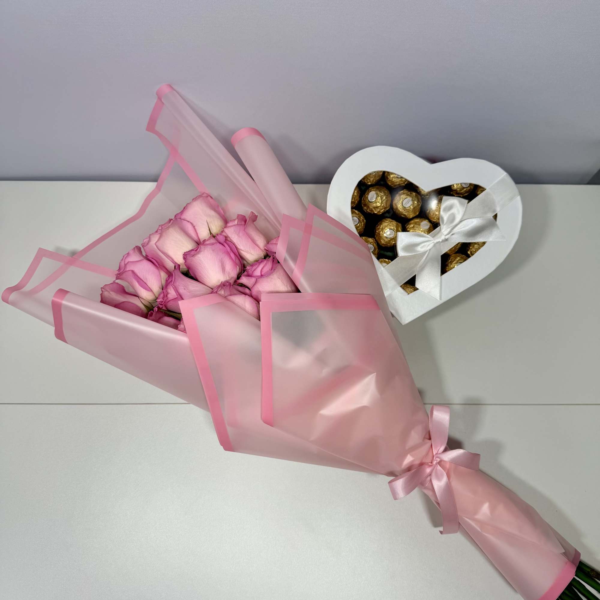 Delicate blush roses wrapped in soft pink paper and paired with a