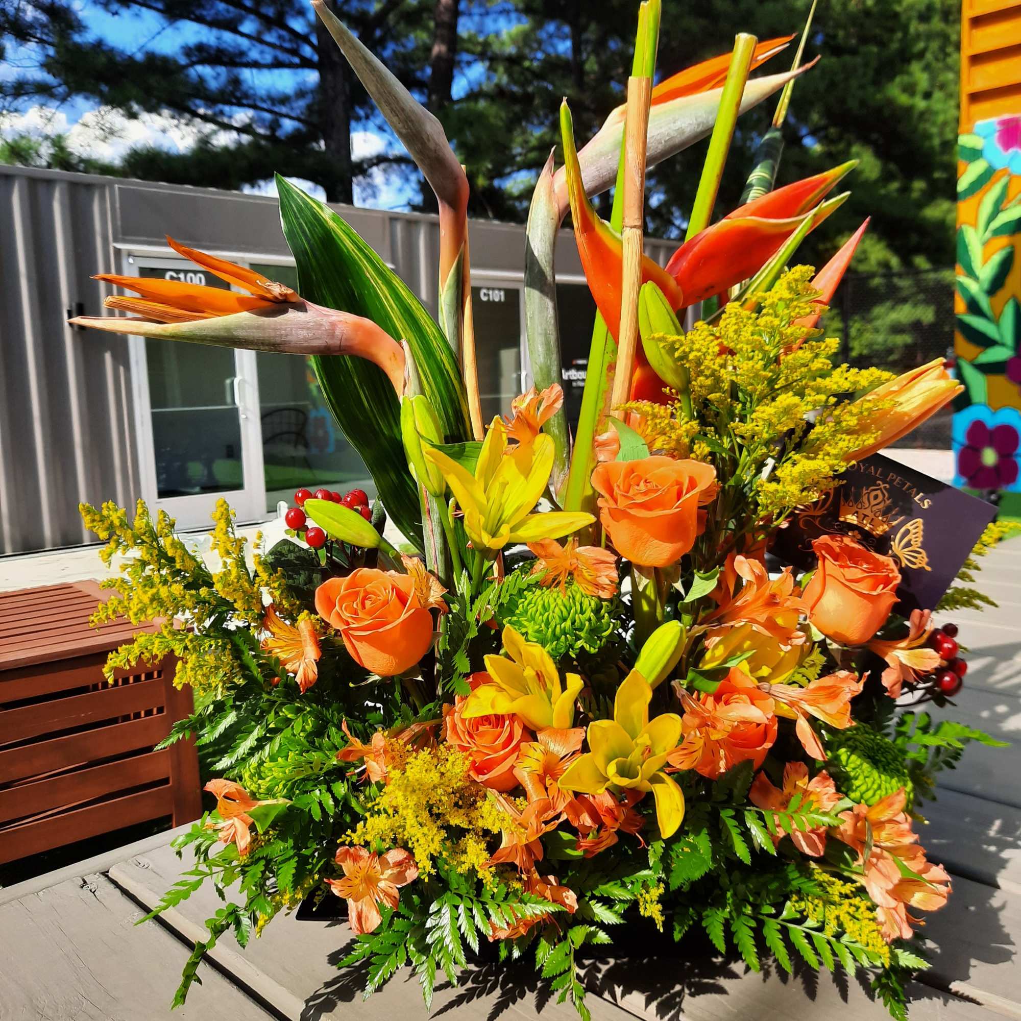 Tropical bouquet with orange roses and bird of paradise flowers