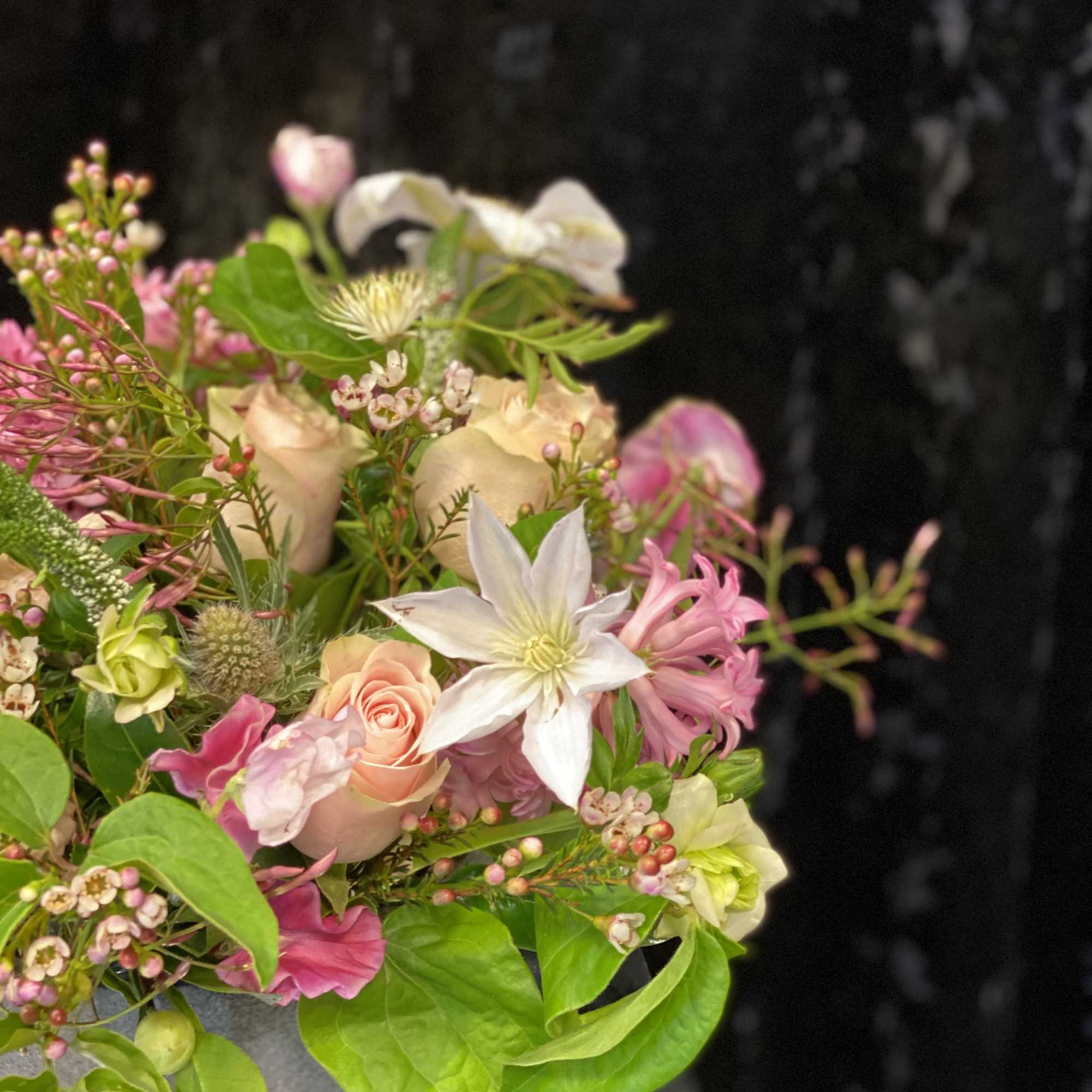Mixed bouquet with pink and white flowers in a gray wrap