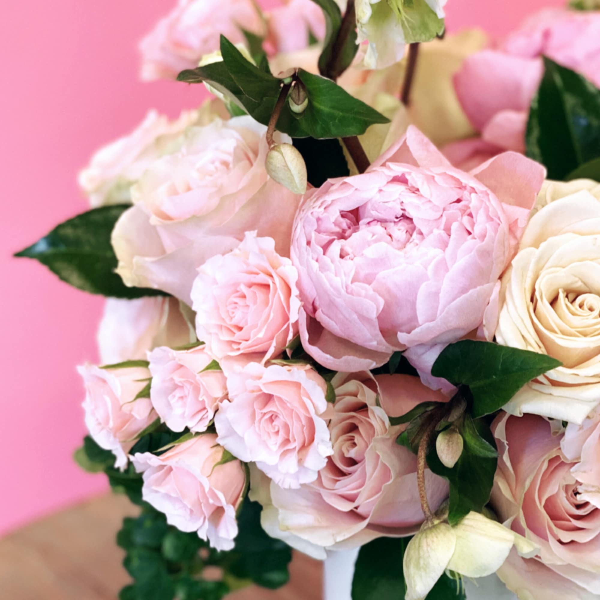 Pink and cream roses in a white vase