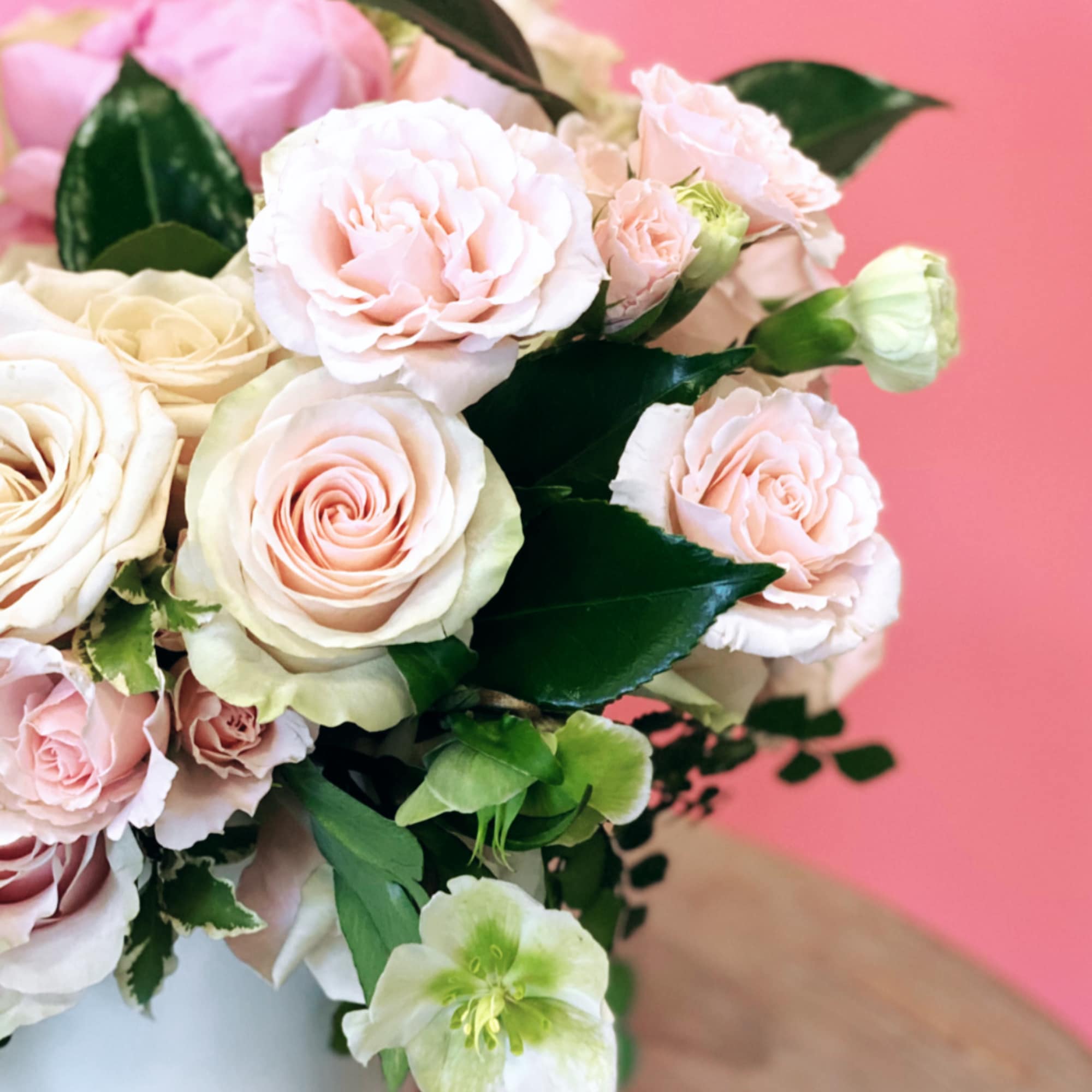 Blush and cream roses arranged in a white vase