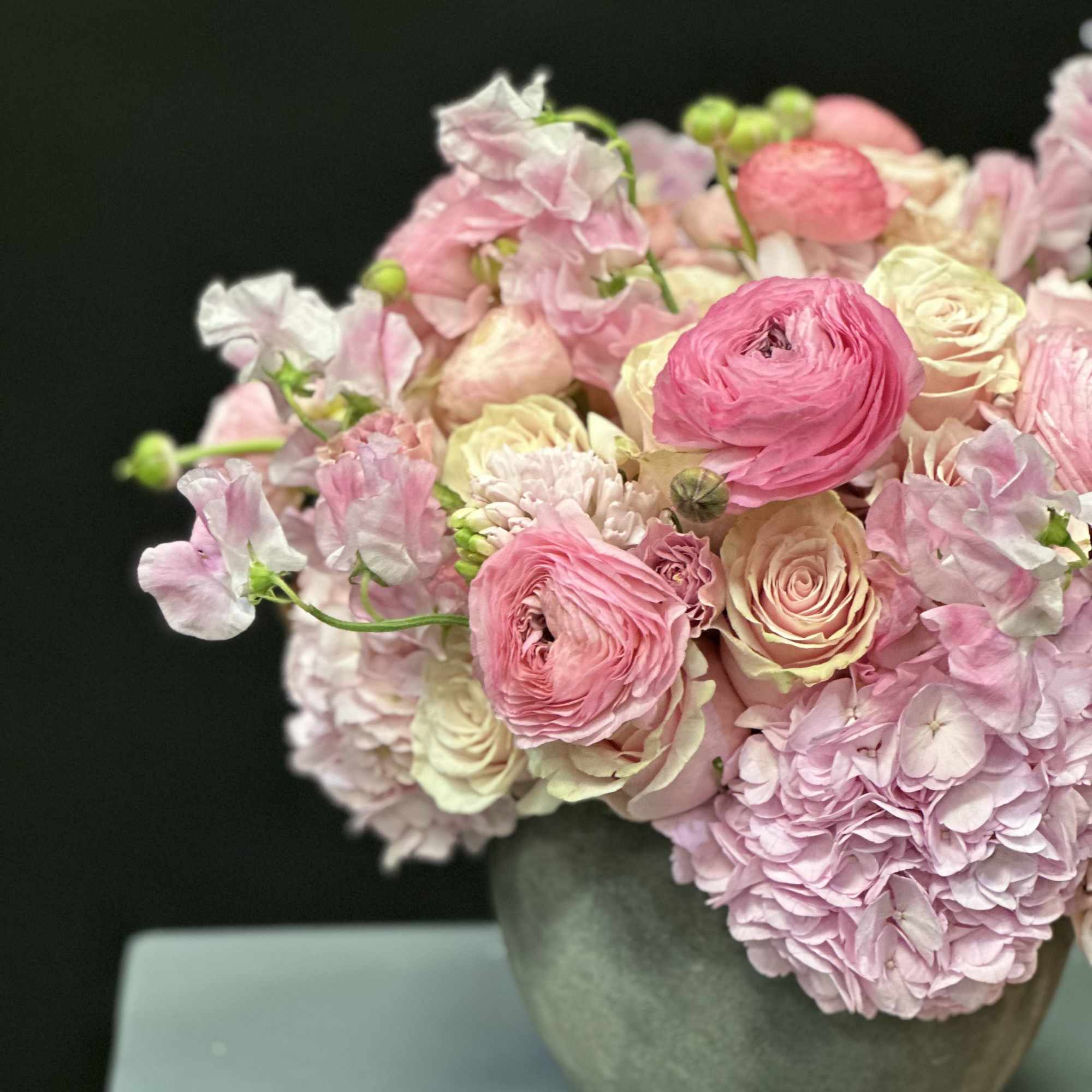 Pink and cream bouquet in a gray vase