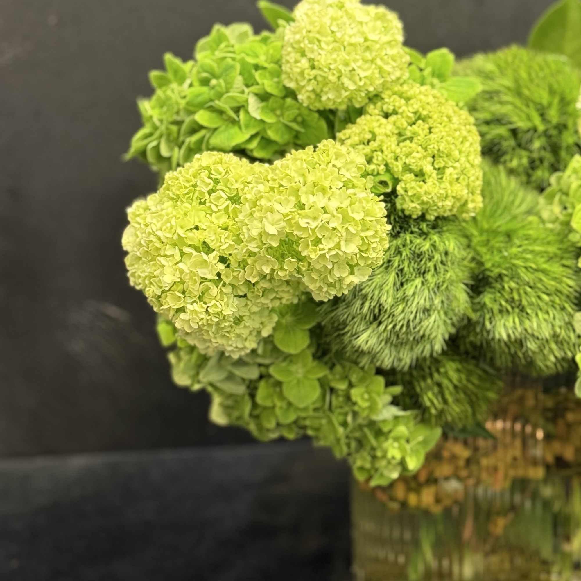 Green hydrangea arrangement in a glass vase