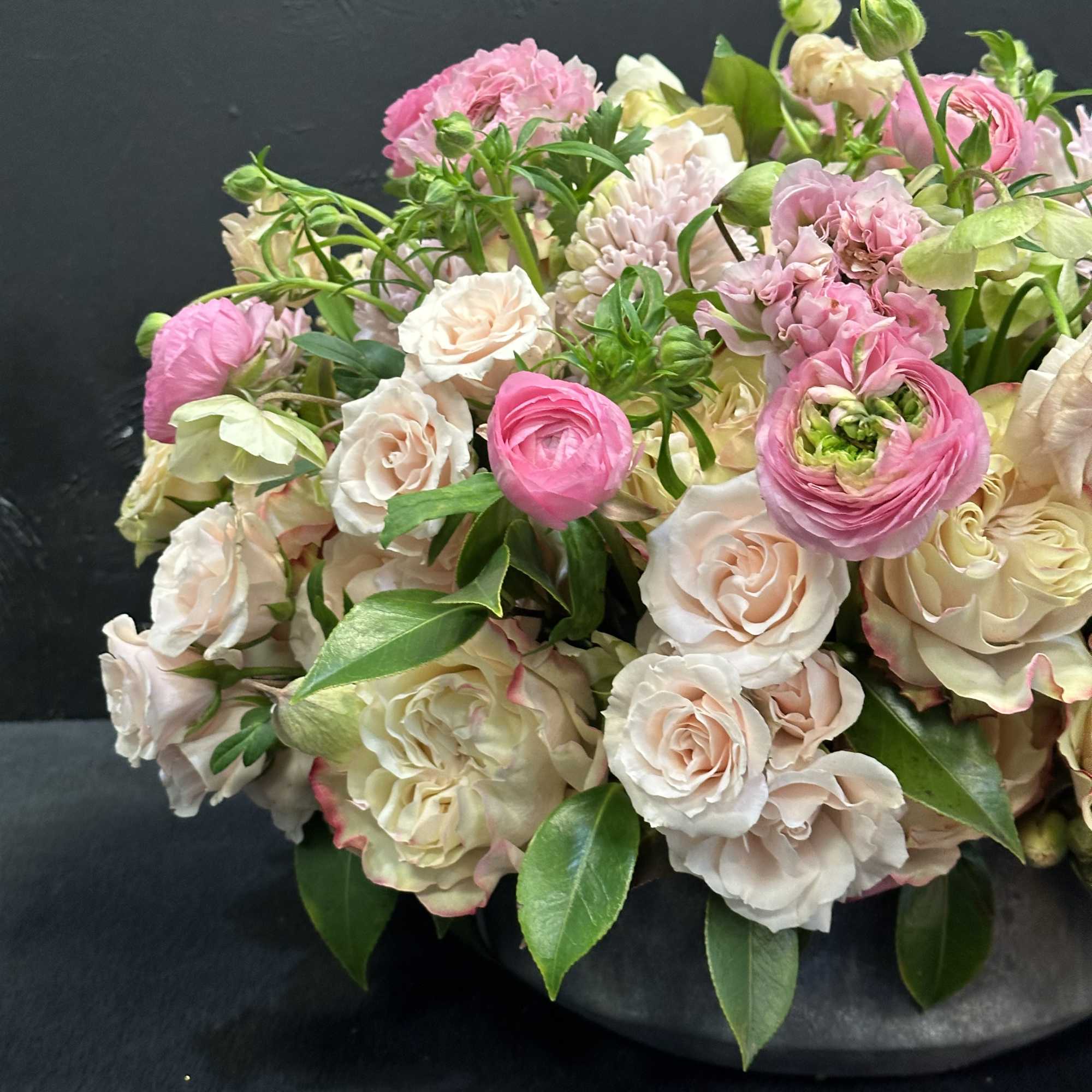 Pink and cream mixed bouquet in a dark vase