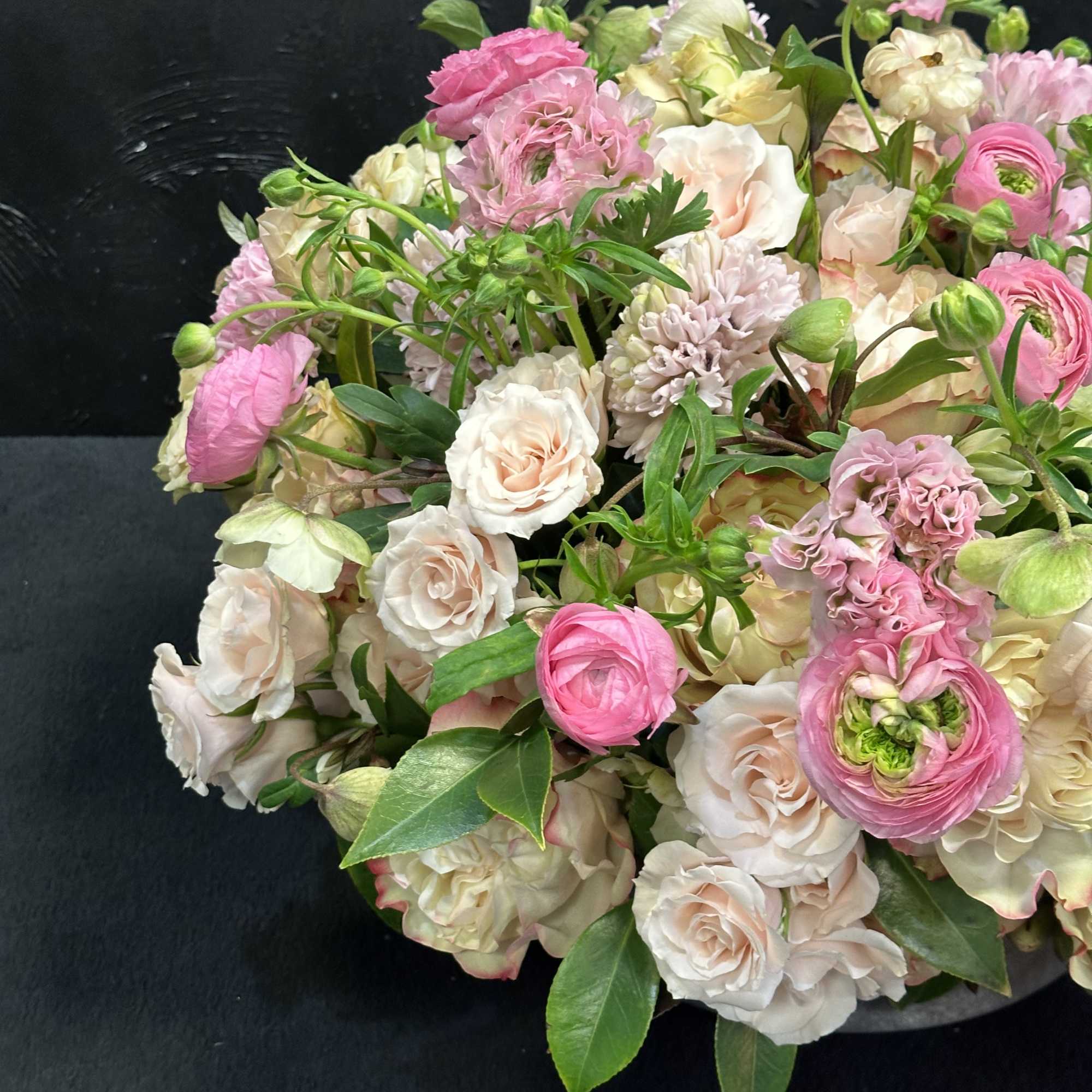 Bouquet of pink and cream flowers with green leaves