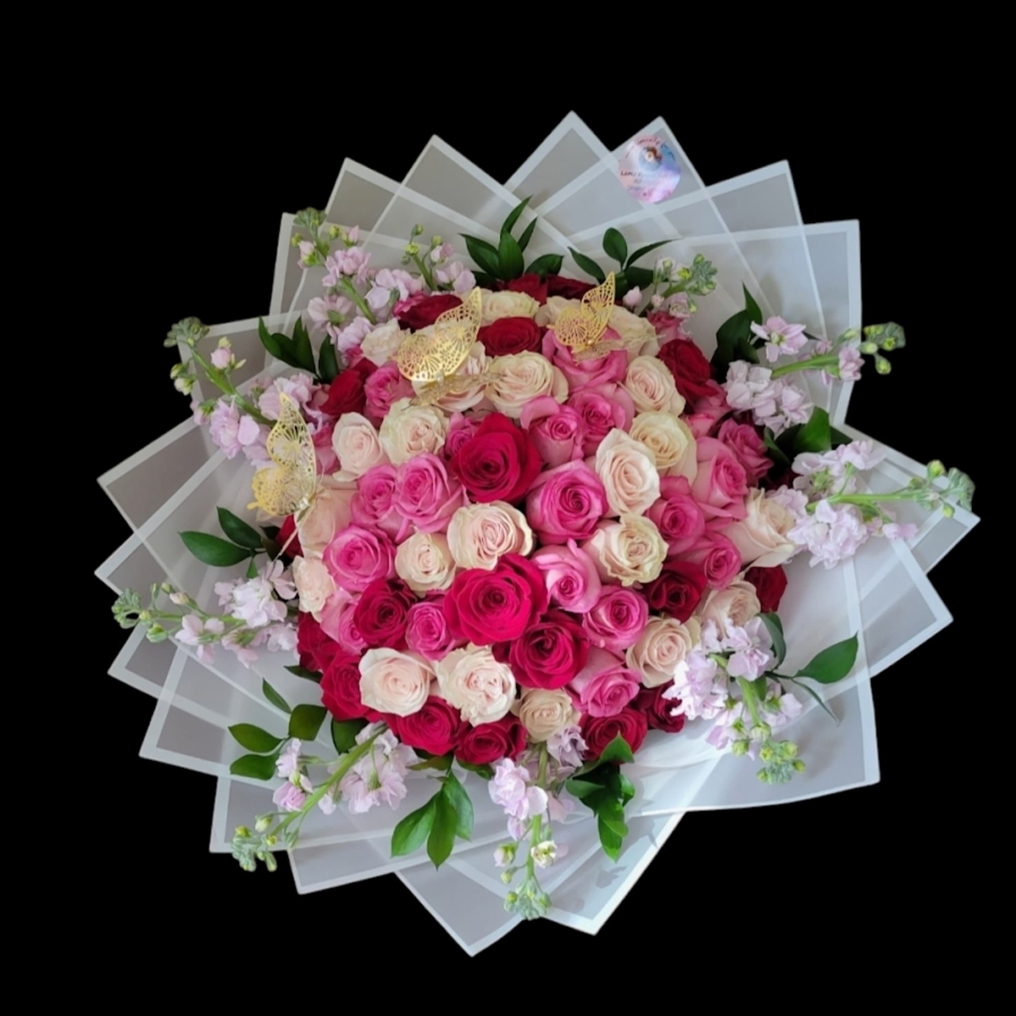 Large bouquet of pink and cream roses with translucent wrapping