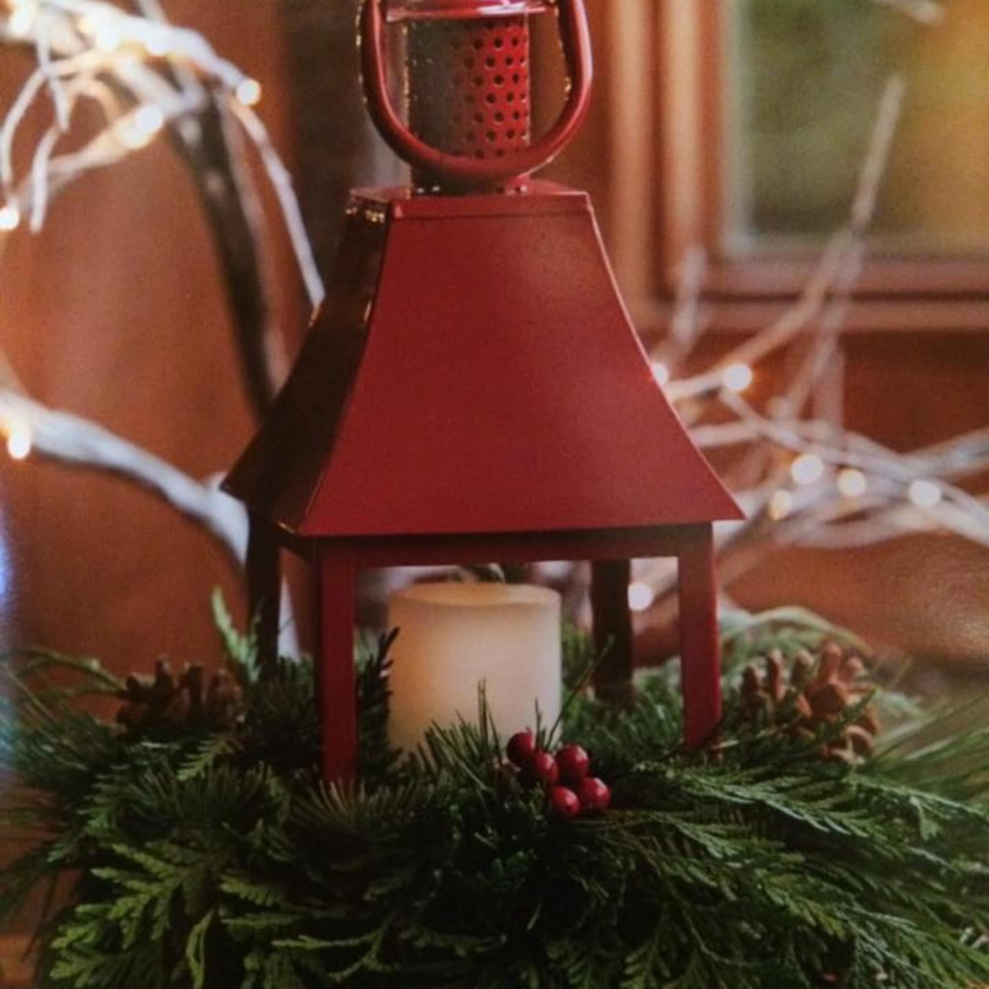 Red lantern centerpiece with a candle and evergreen base