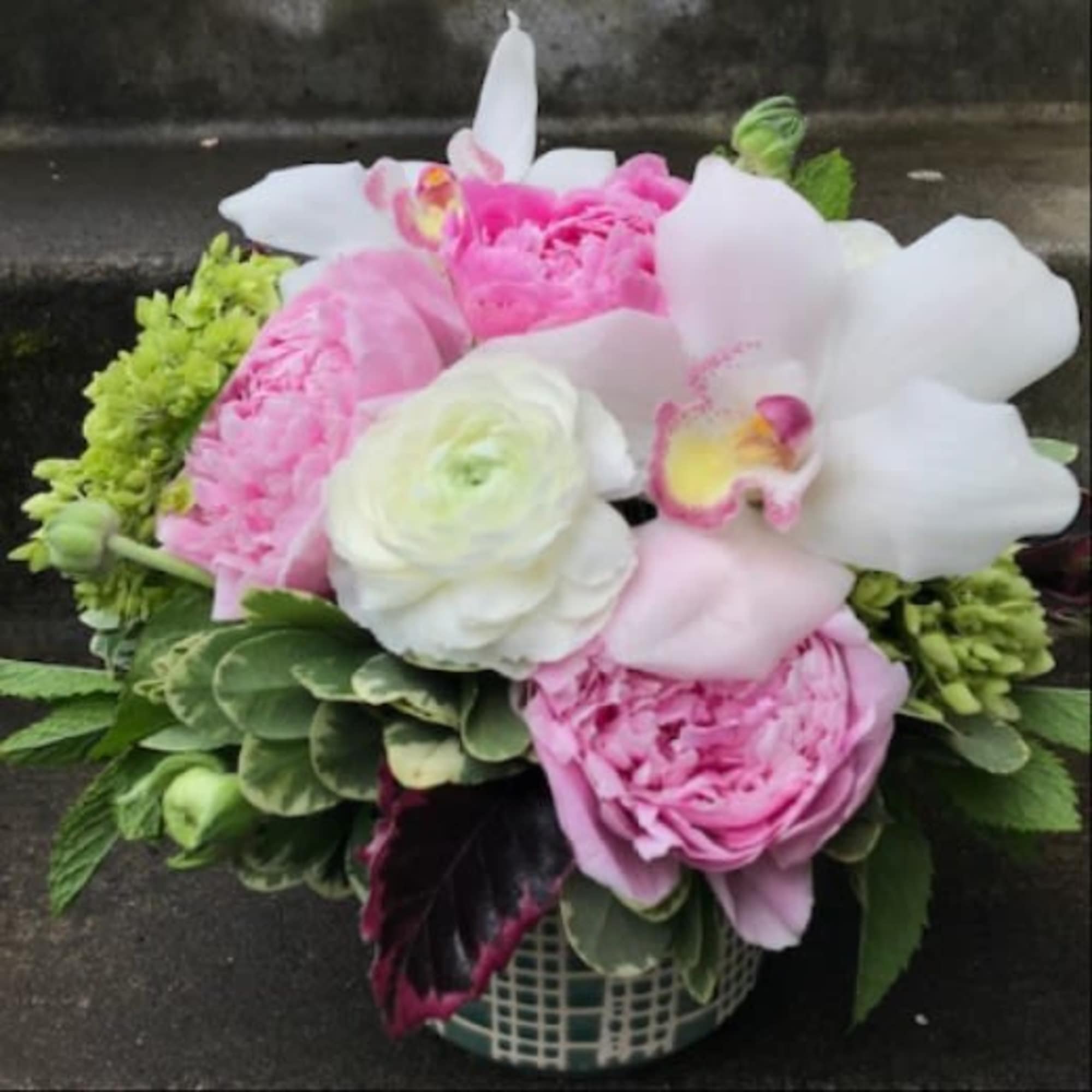 A designer's choice custom mixed floral arrangement with peonies, hydrangea, orchids, and