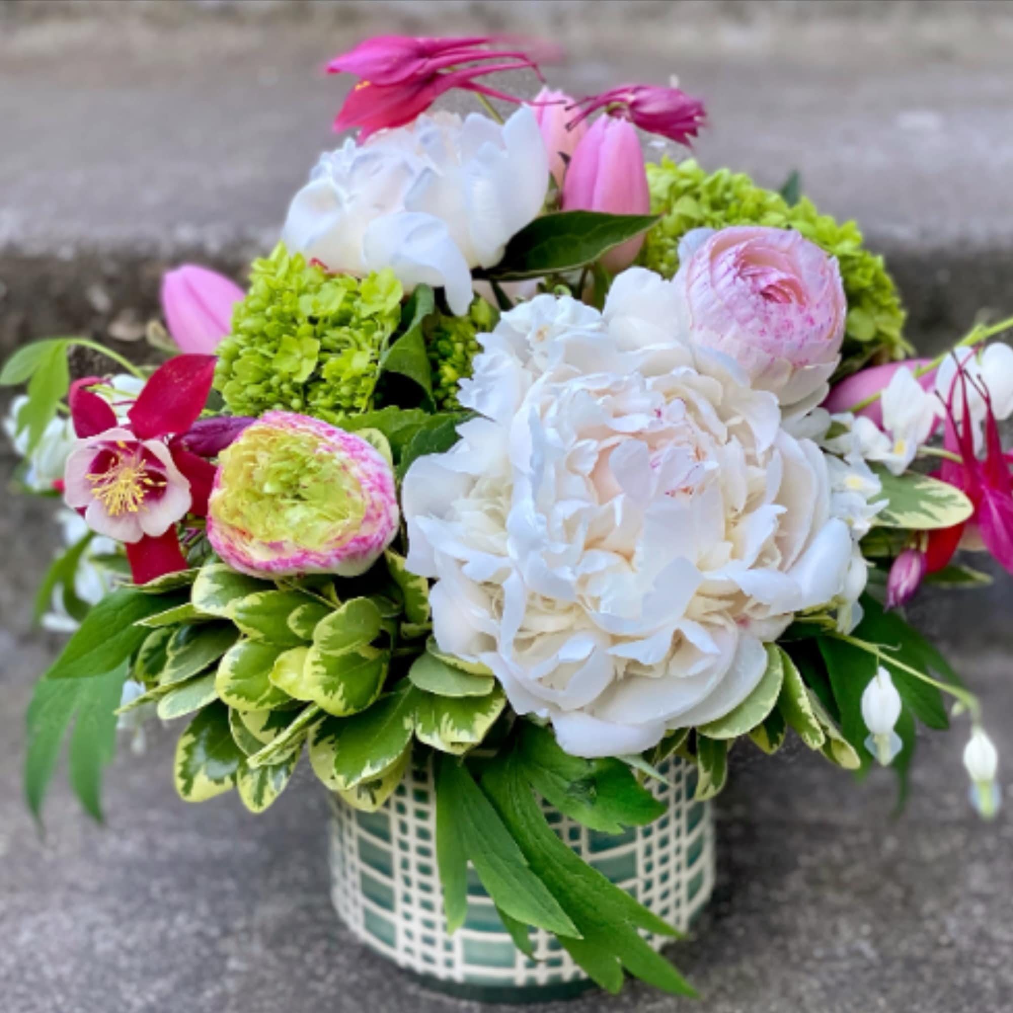 A designer's choice custom mixed floral arrangement with peonies, hydrangea, orchids, and