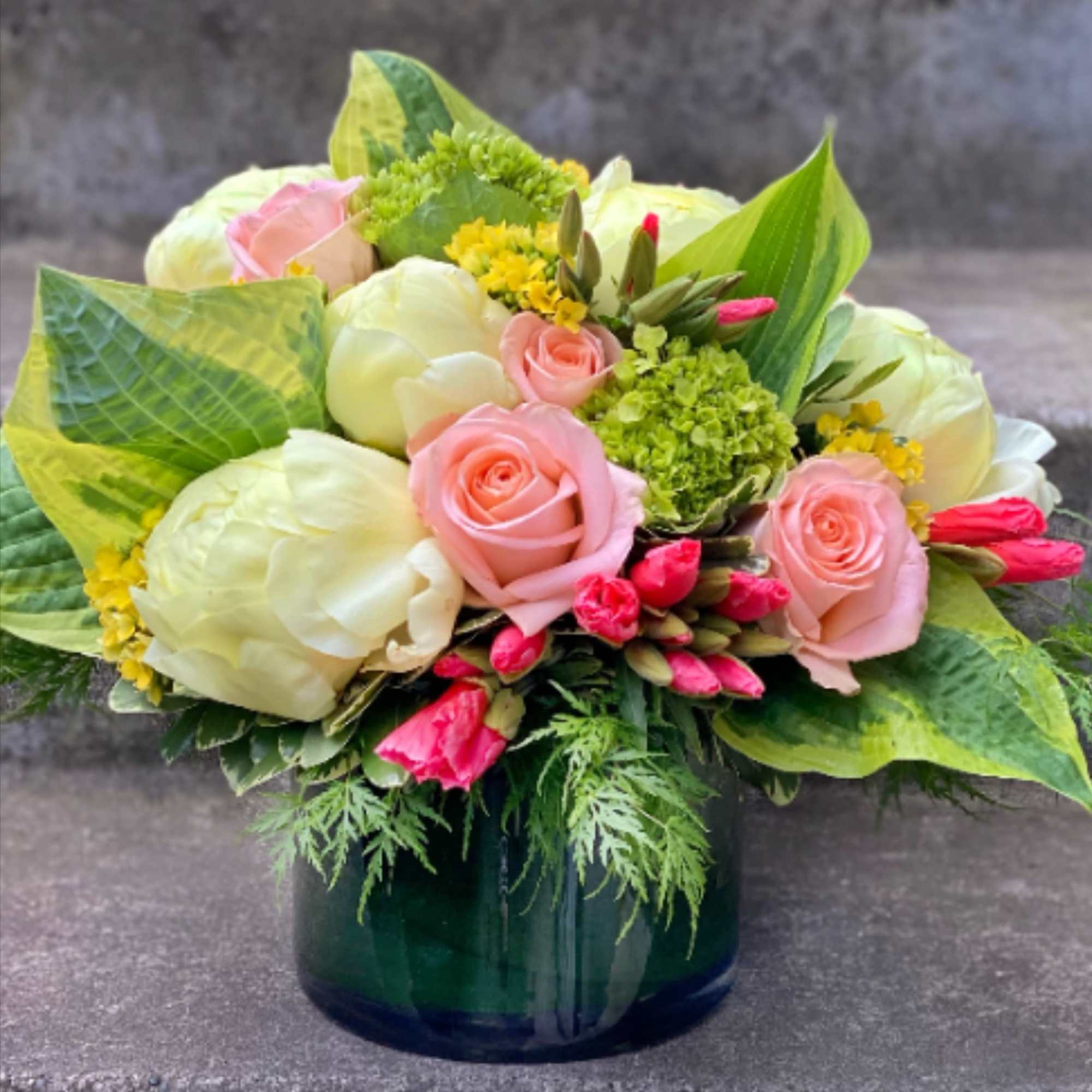 A designer's choice custom mixed floral arrangement with peonies, hydrangea, orchids, and