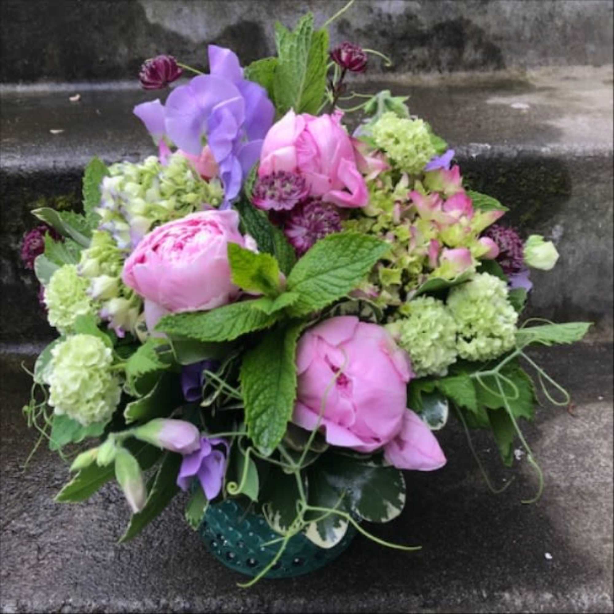 A designer's choice custom mixed floral arrangement with peonies, hydrangea, orchids, and
