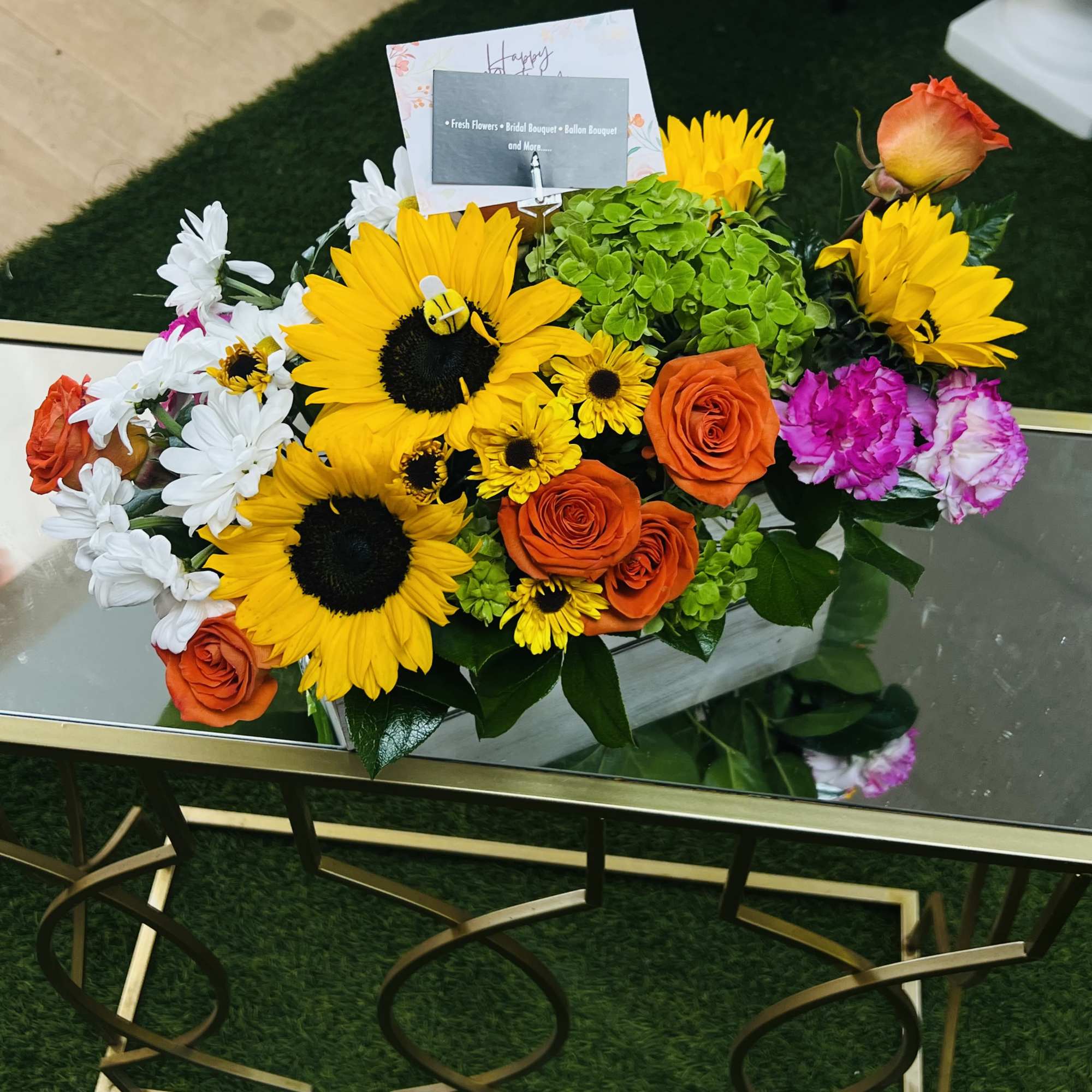 Mixed bouquet with sunflowers, orange roses, white daisies, and pink carnations