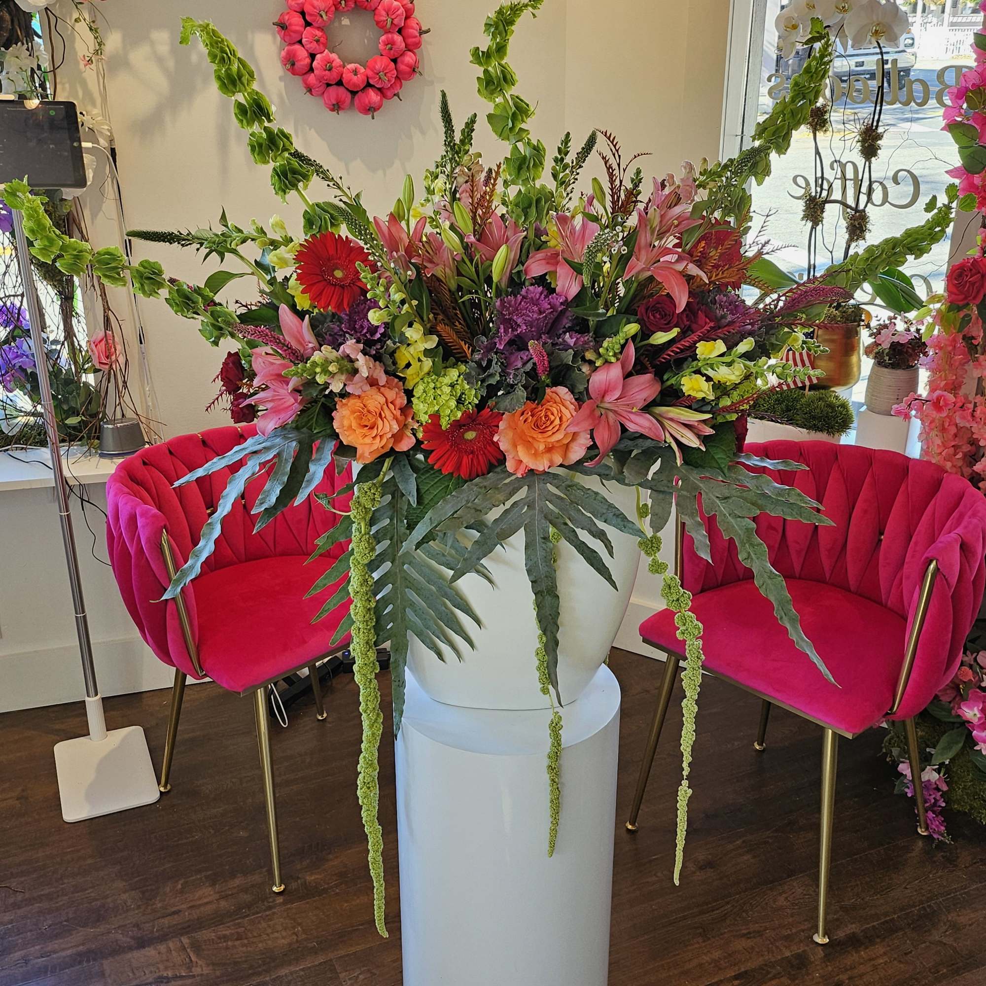 Large mixed floral arrangement in a white pedestal vase
