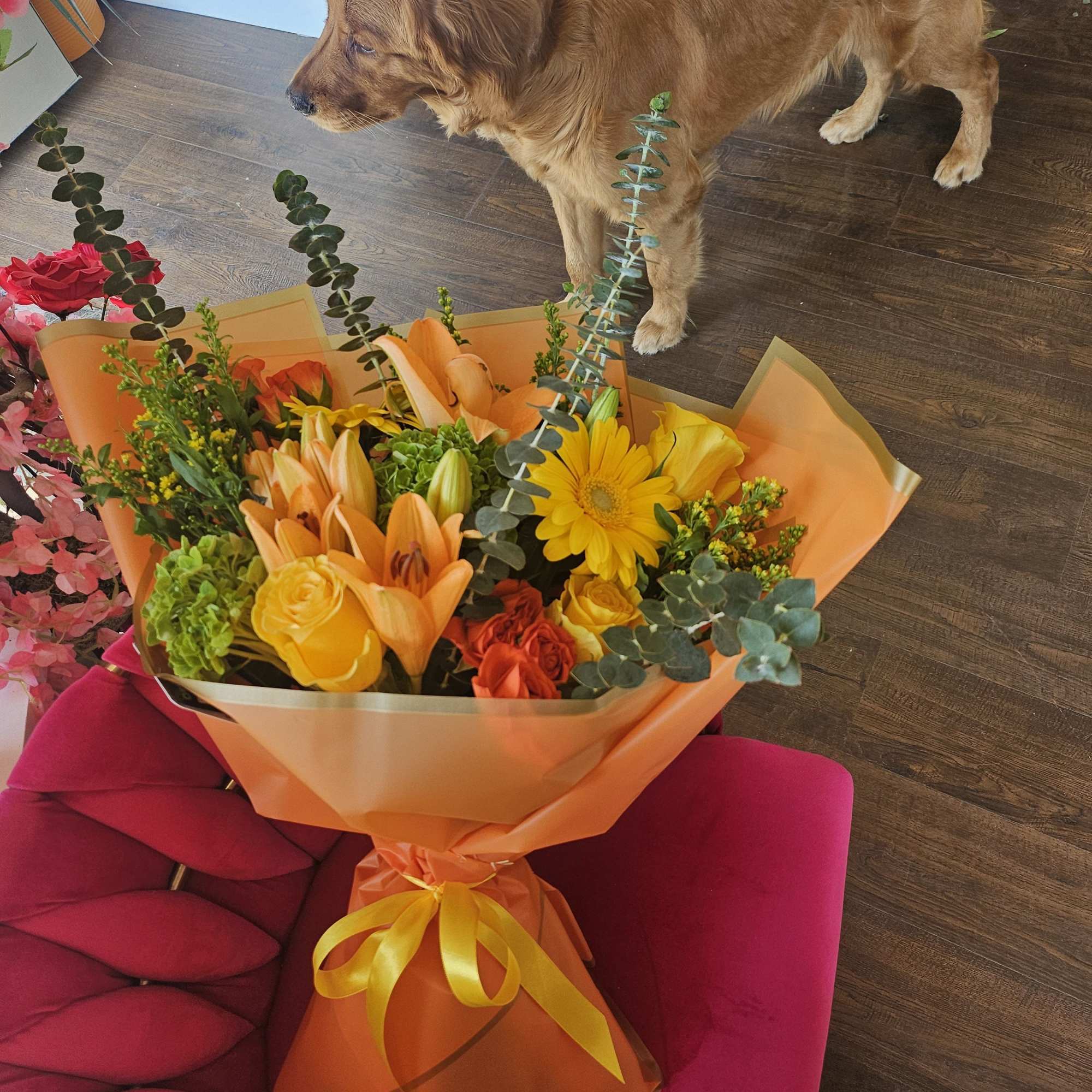 Orange and yellow mixed bouquet wrapped in orange paper with a ribbon
