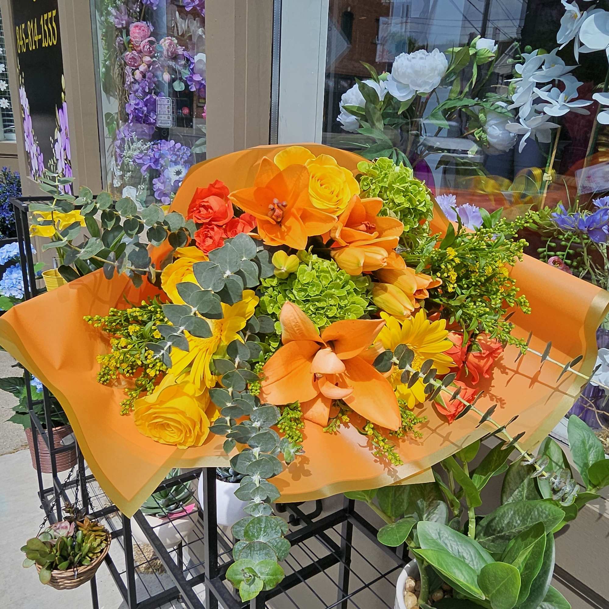 Bright orange and yellow bouquet with orchids and roses