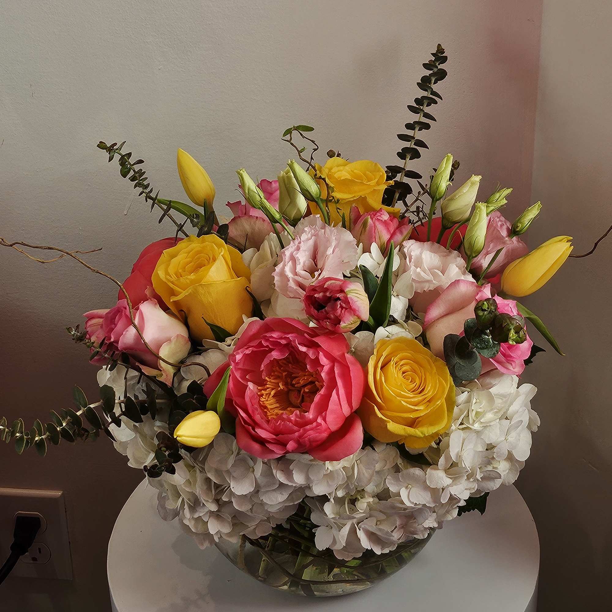 Mixed bouquet of pink and yellow flowers in a glass vase