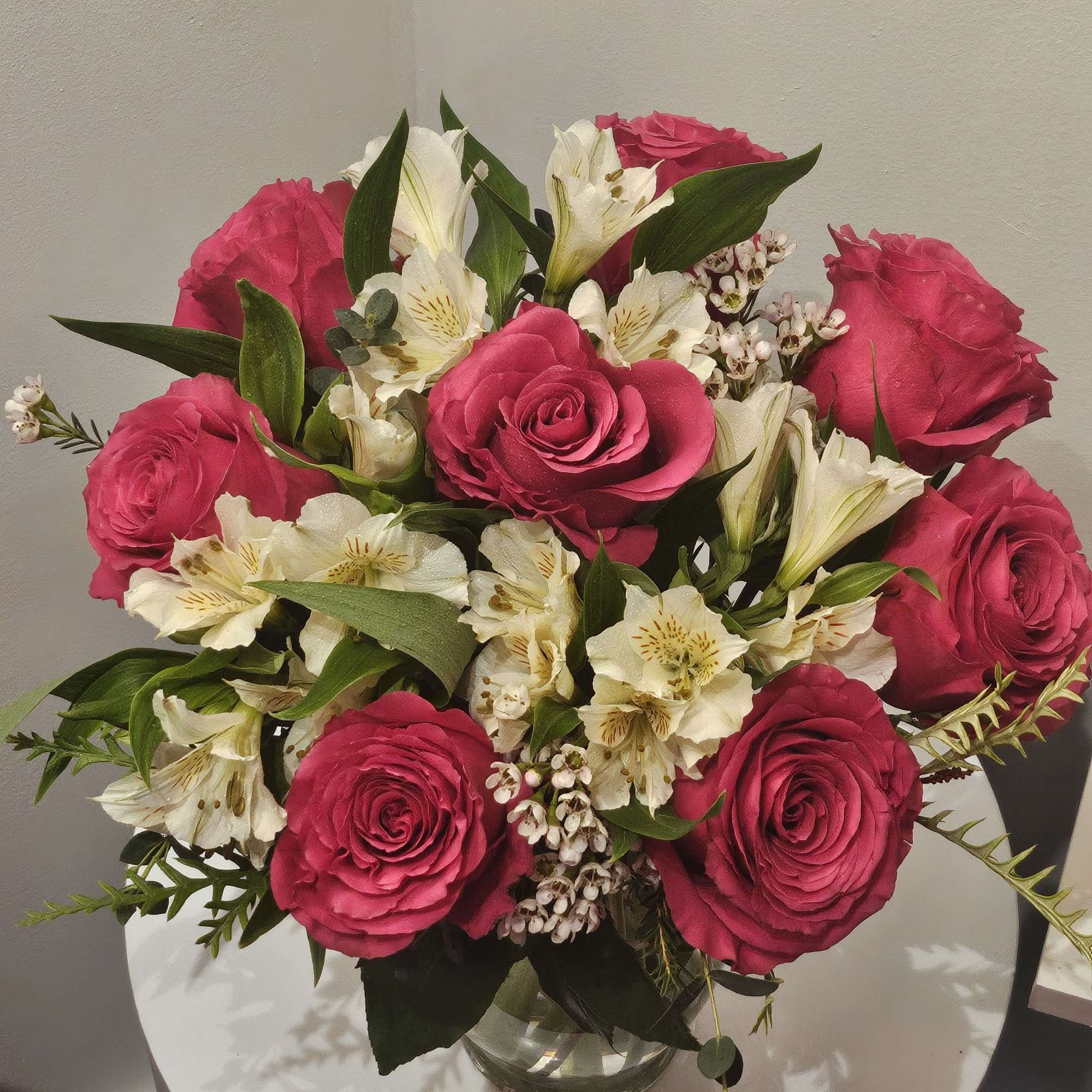 Pink roses and white alstroemeria in a clear glass vase