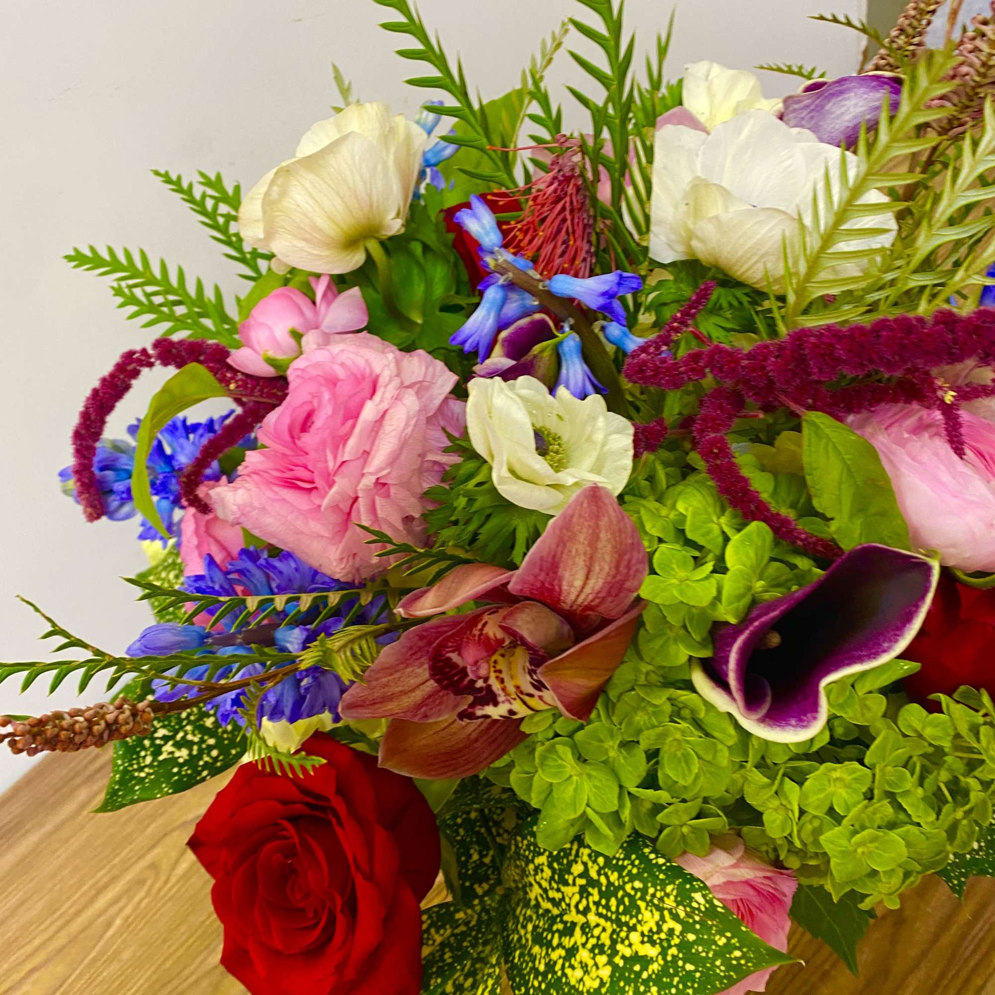 In a glass vasr combinations of pink roses white ranunculus and no
