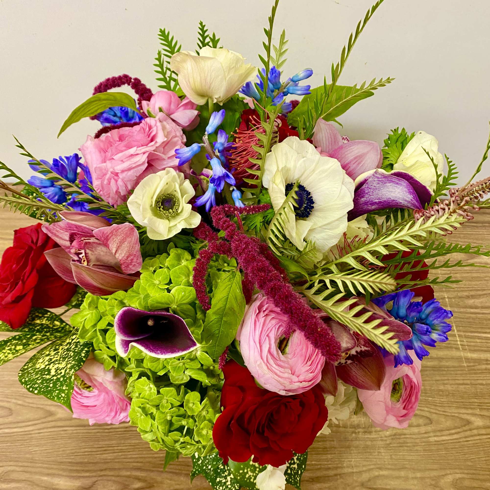 In a glass vasr combinations of pink roses white ranunculus and no