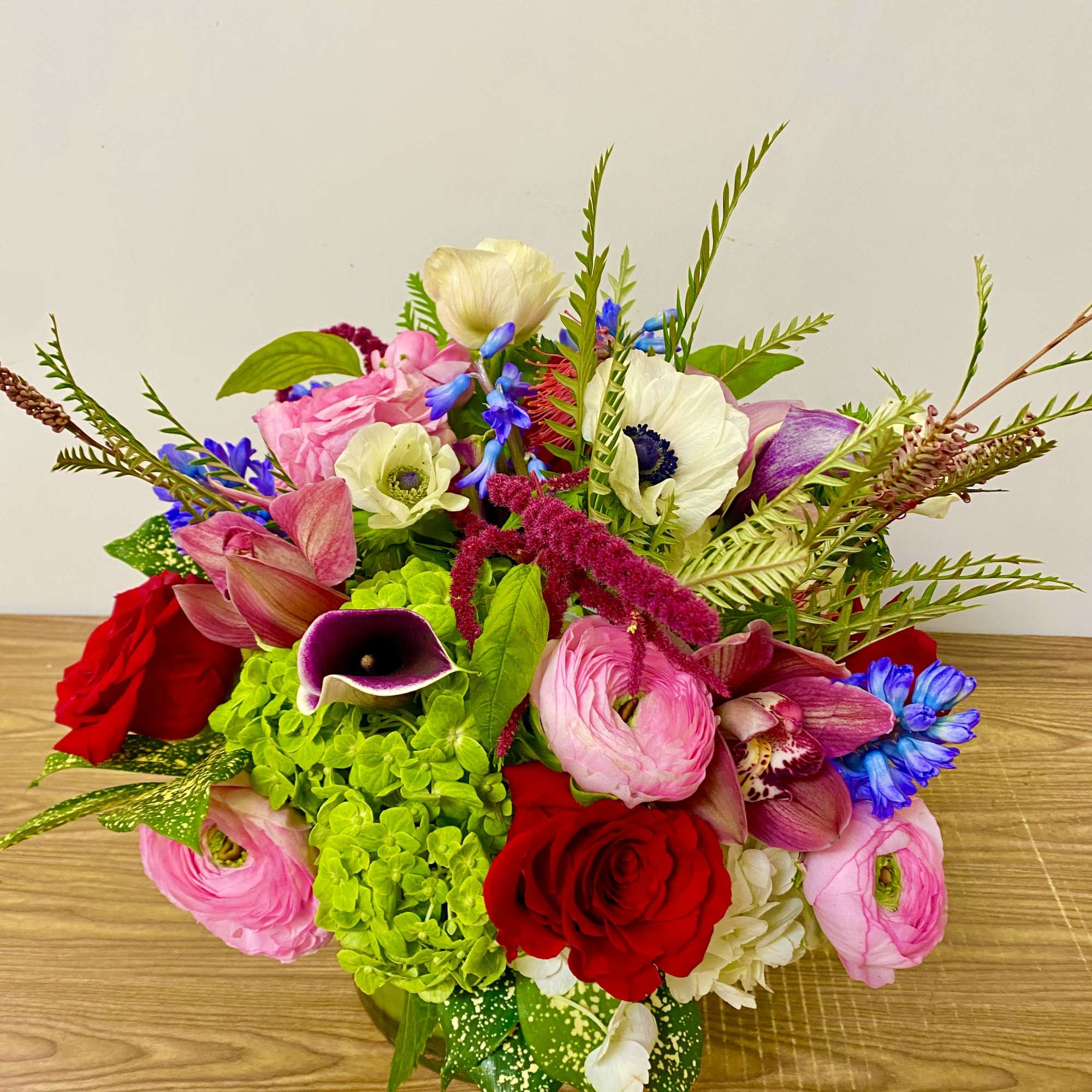 In a glass vasr combinations of pink roses white ranunculus and no
