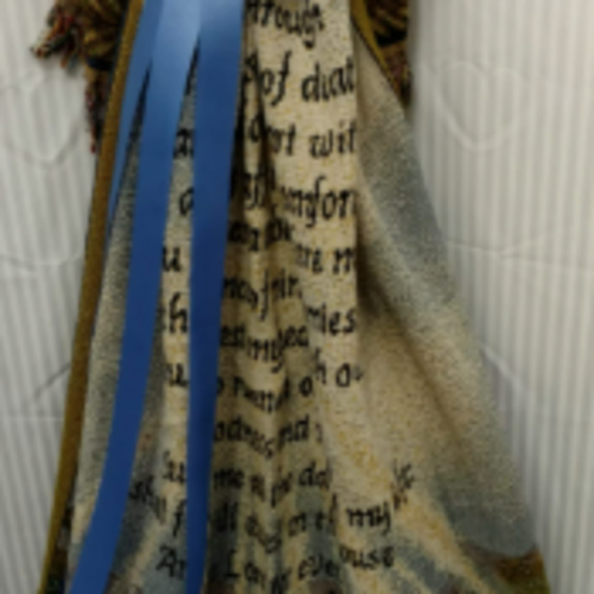 A decorative blanket with a large blue bow draped over it