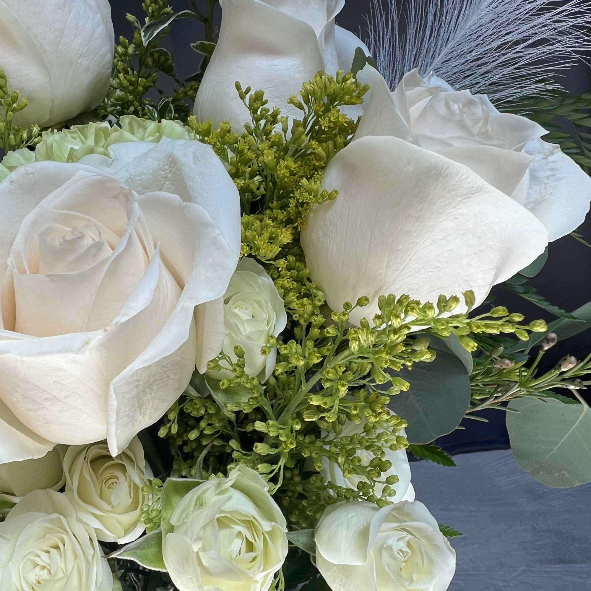 White rose bouquet with green filler and a butterfly accent