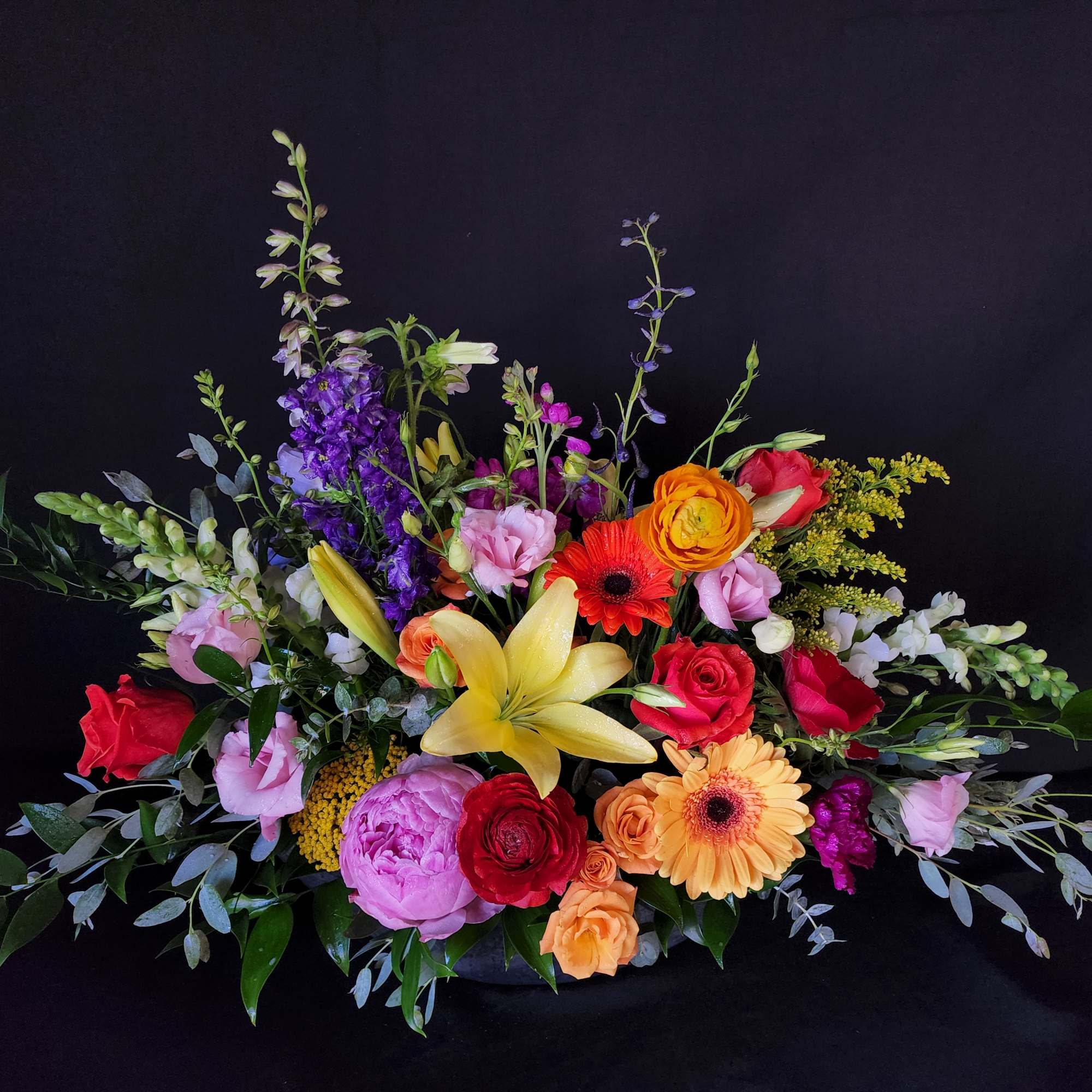 Colorful mixed flower arrangement with lilies, roses, and gerbera daisies