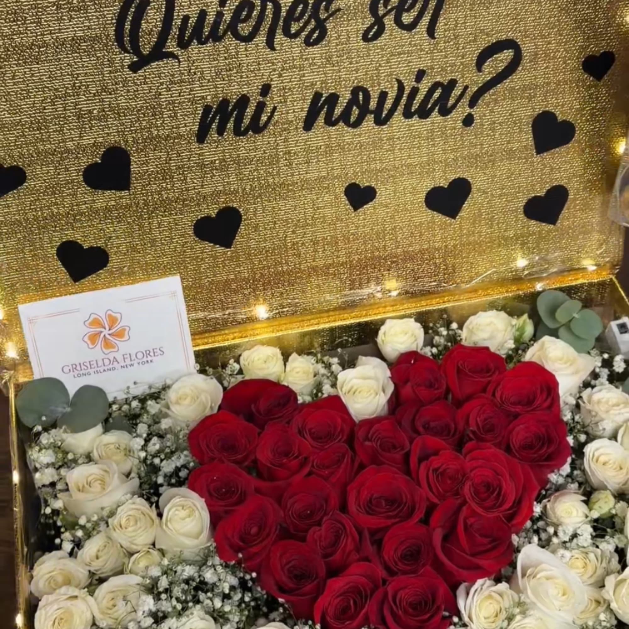 Heart-shaped red and white rose arrangement in a gold gift box