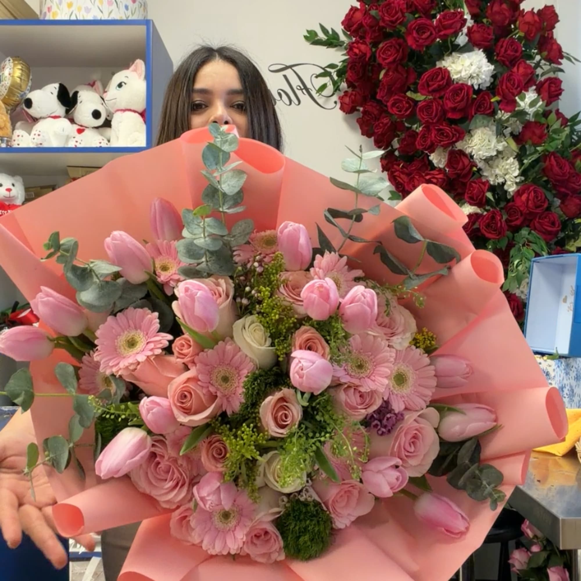 Large pink bouquet with roses, tulips, and daisies wrapped in peach paper