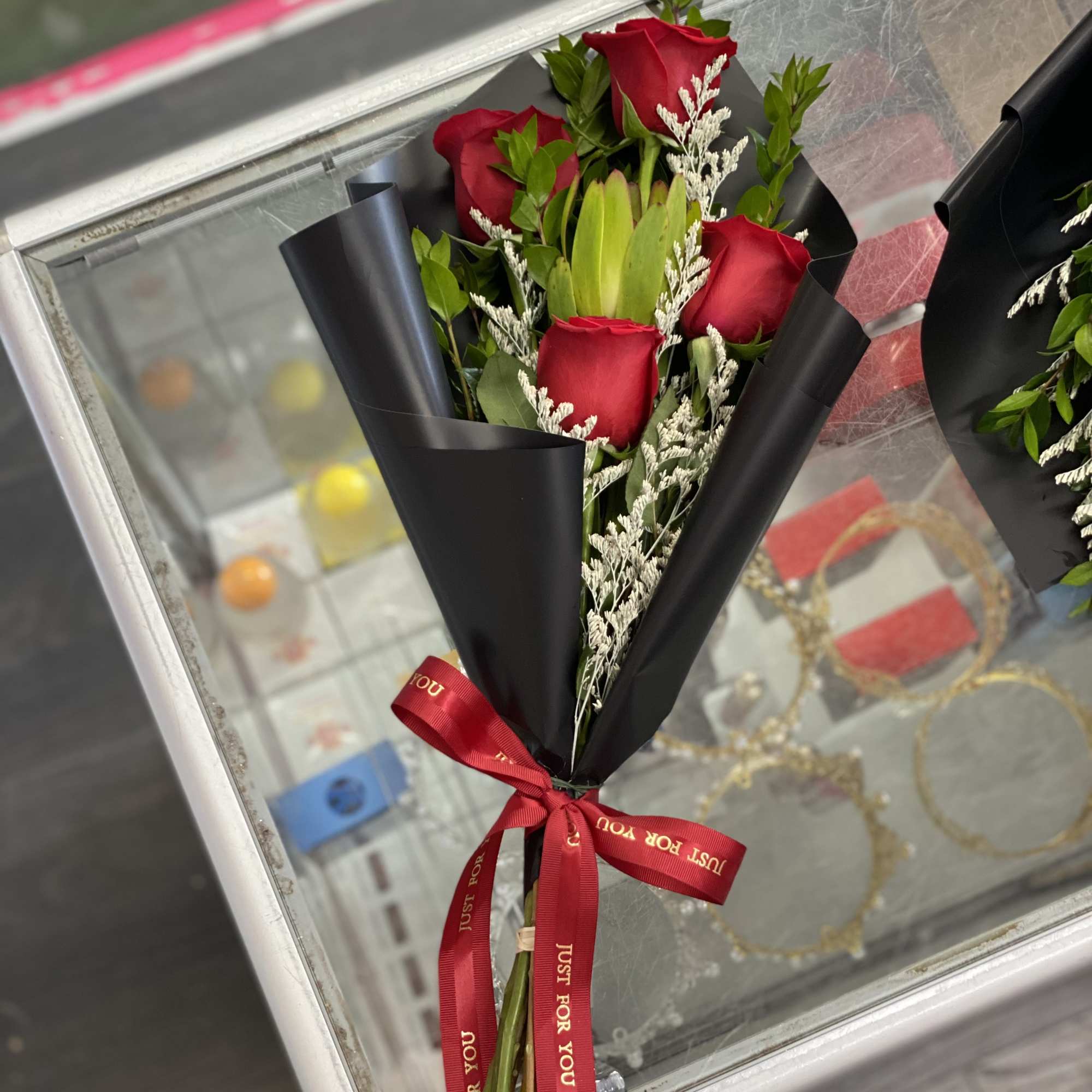 Bouquet of red roses wrapped in black paper with a red ribbon