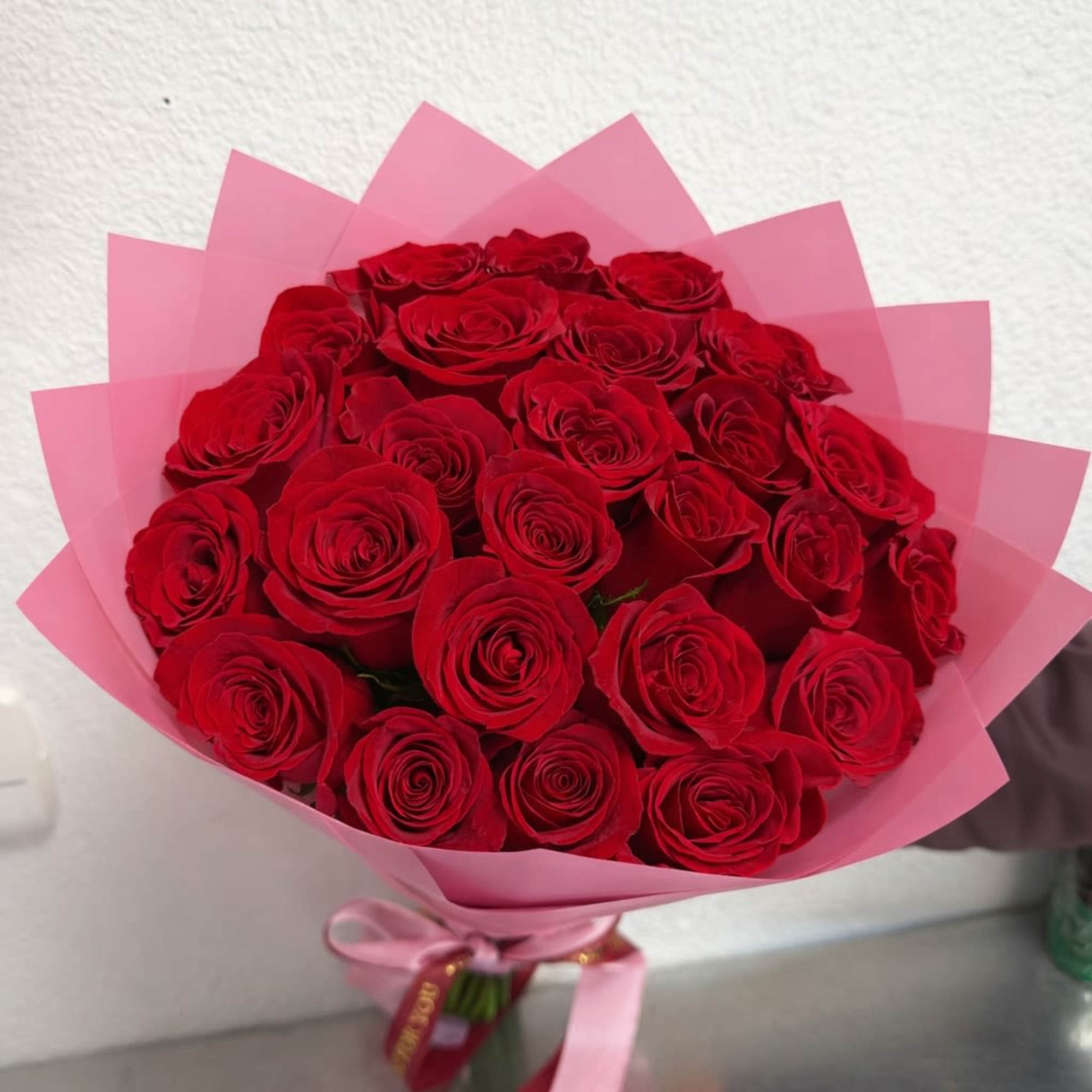 Bouquet of red roses wrapped in pink paper