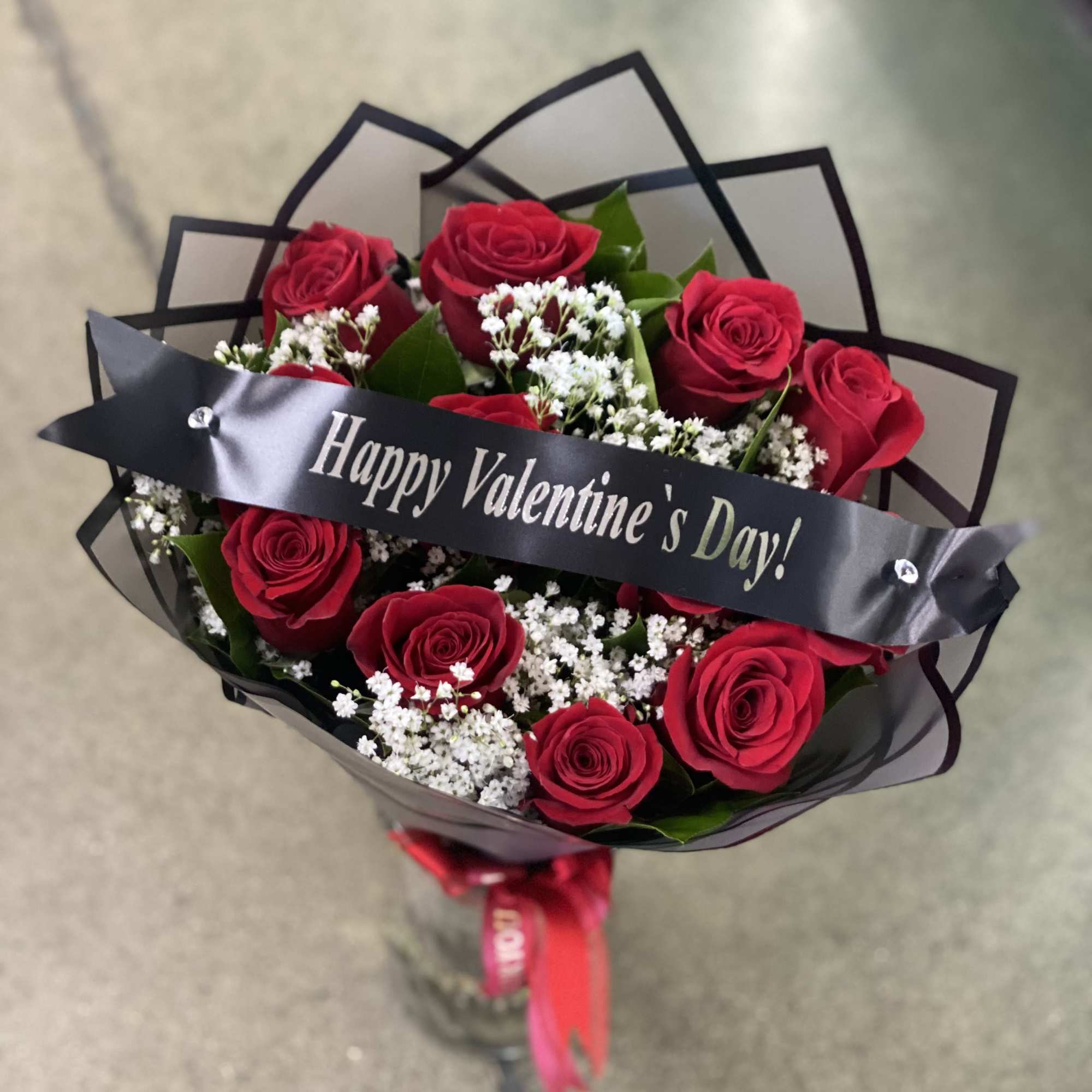 Bouquet of red roses with white baby's breath and a Valentine ribbon