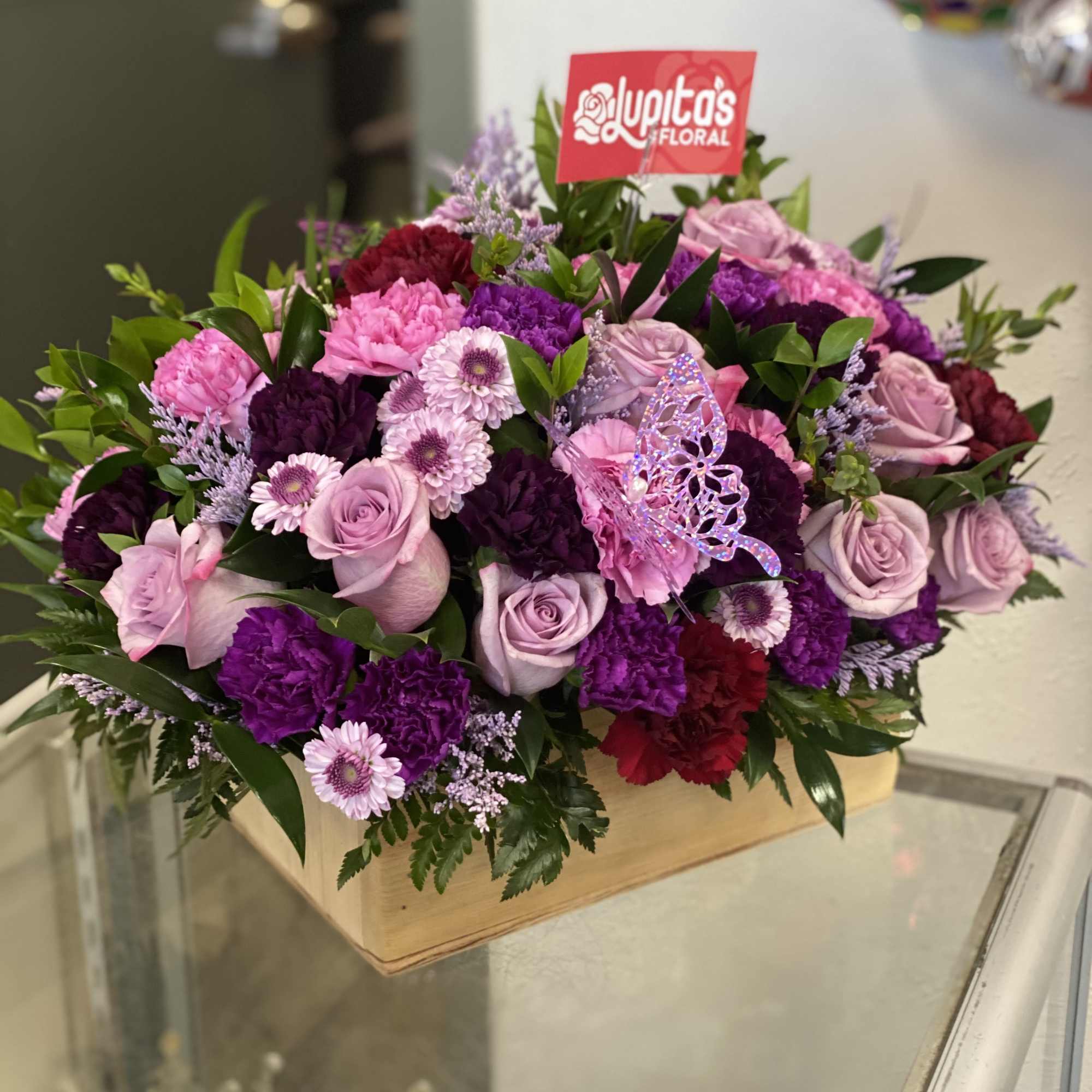 Pink and purple mixed flower arrangement in a wooden box