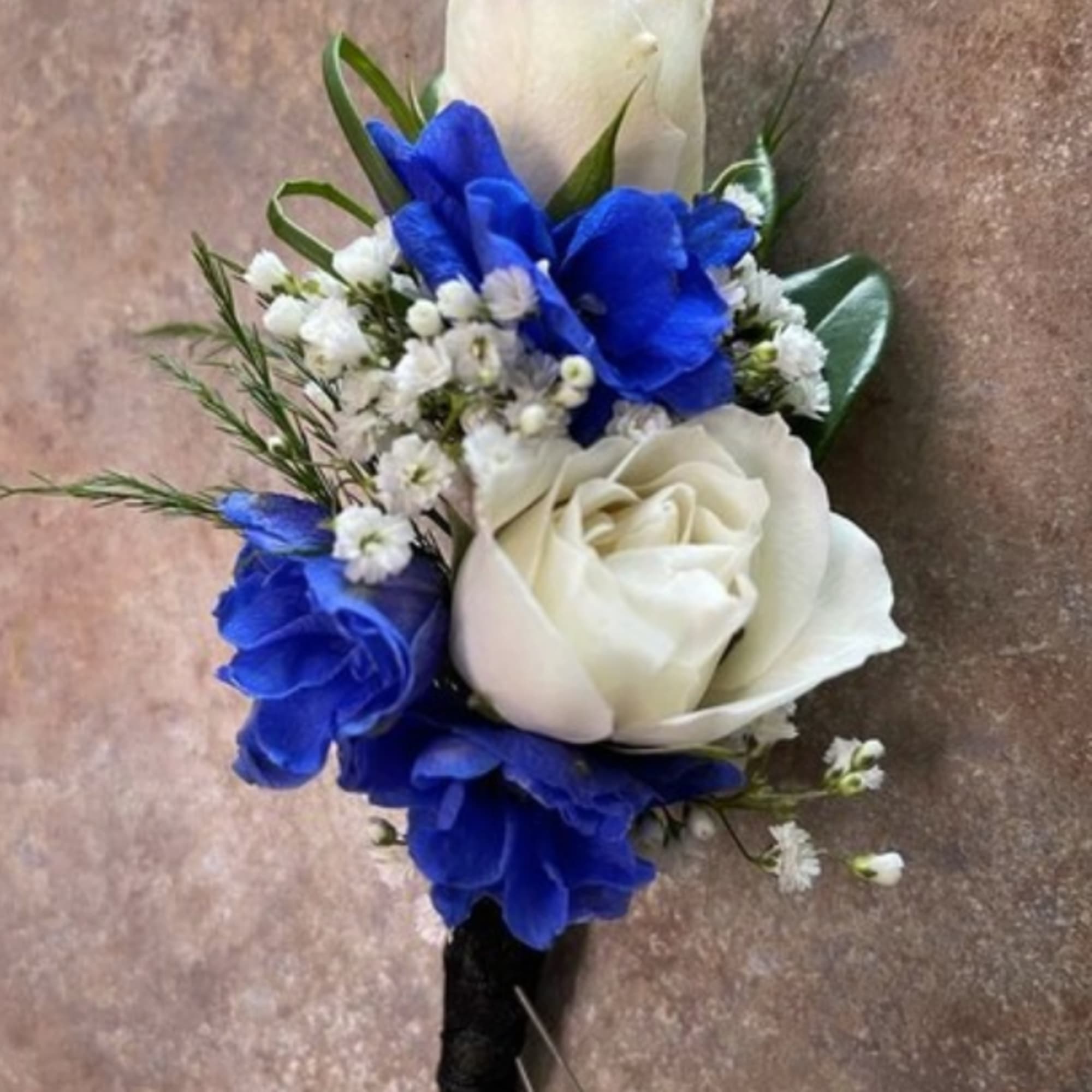 Blue and white rose boutonniere with baby's breath
