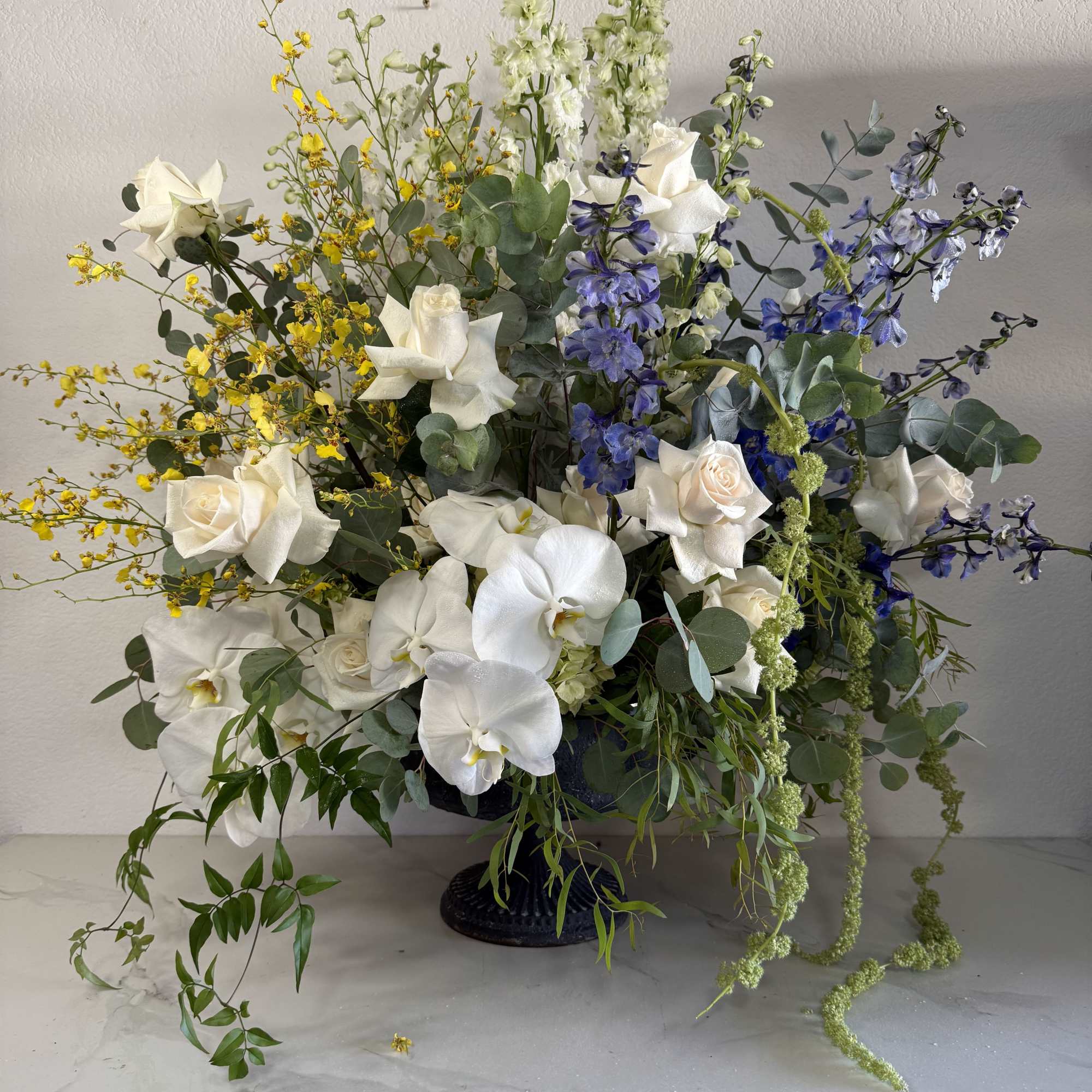 White phalaenopsis orchids and white roses take center stage in this large