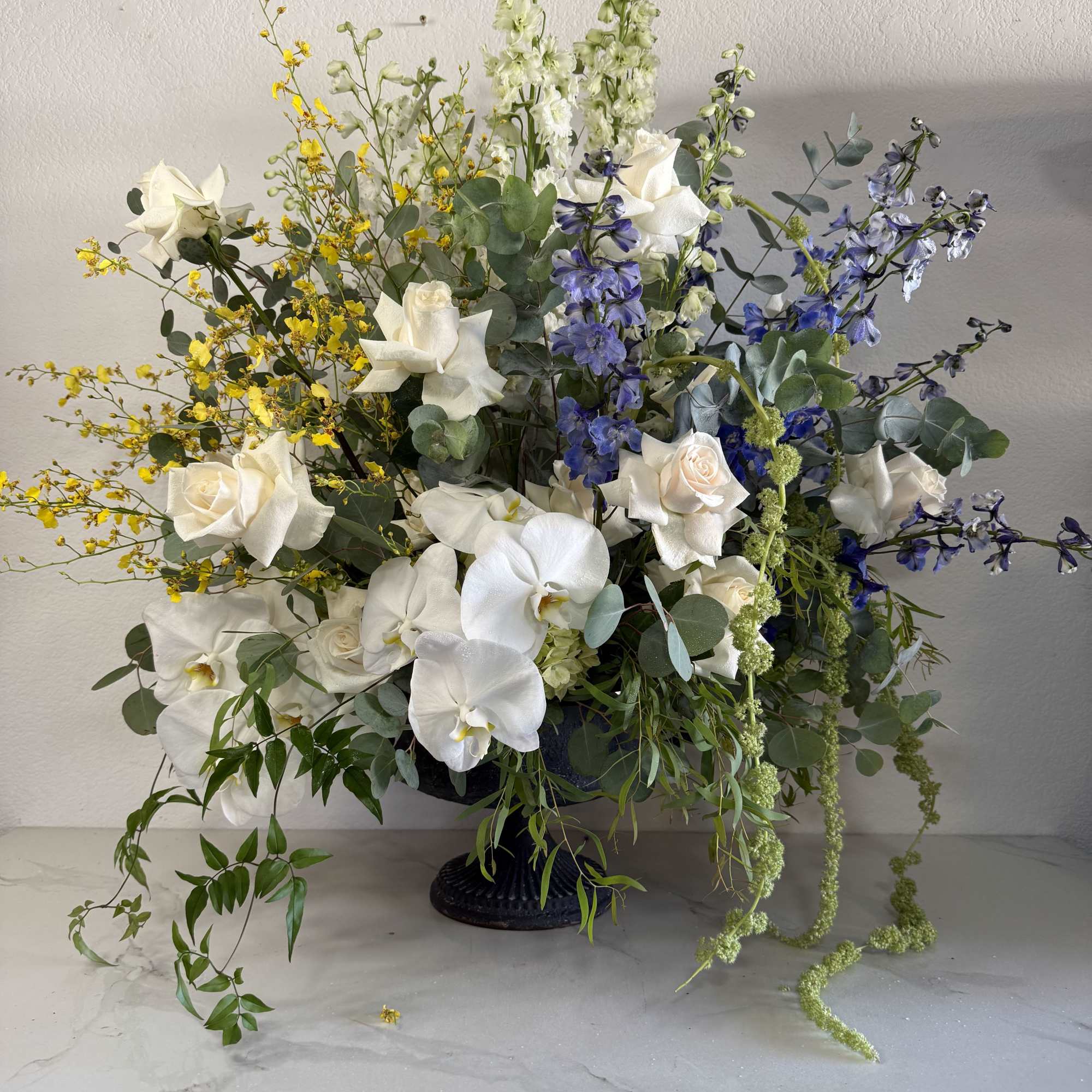 White phalaenopsis orchids and white roses take center stage in this large
