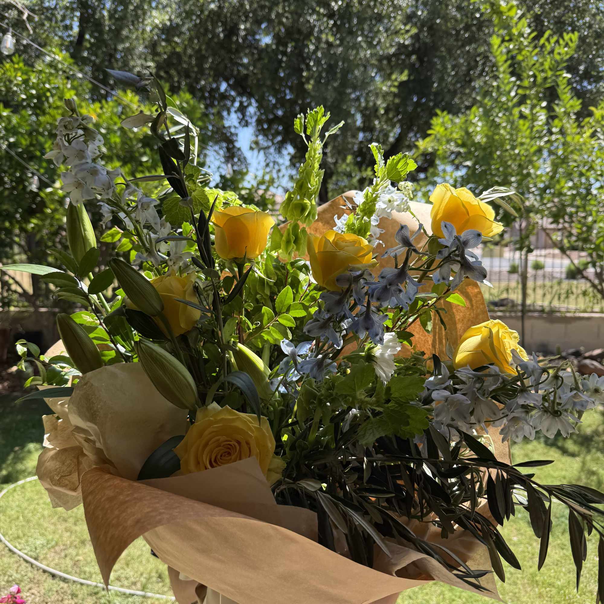 Bright yellow roses take center stage in this hand-tied flower arrangement, sending