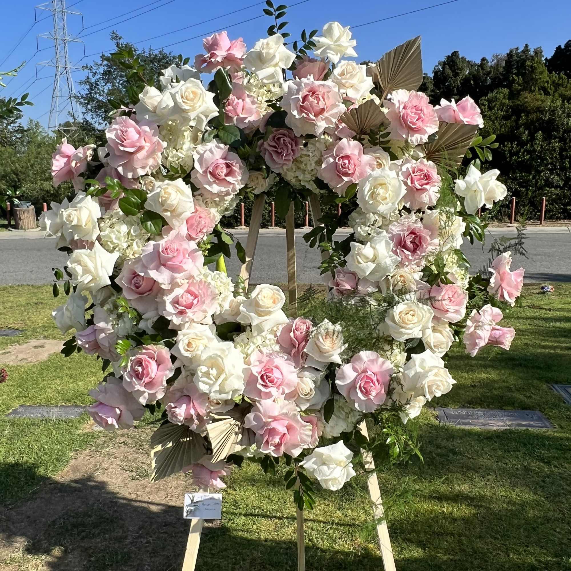 Large heart-shaped floral display of pink and white roses on a stand
