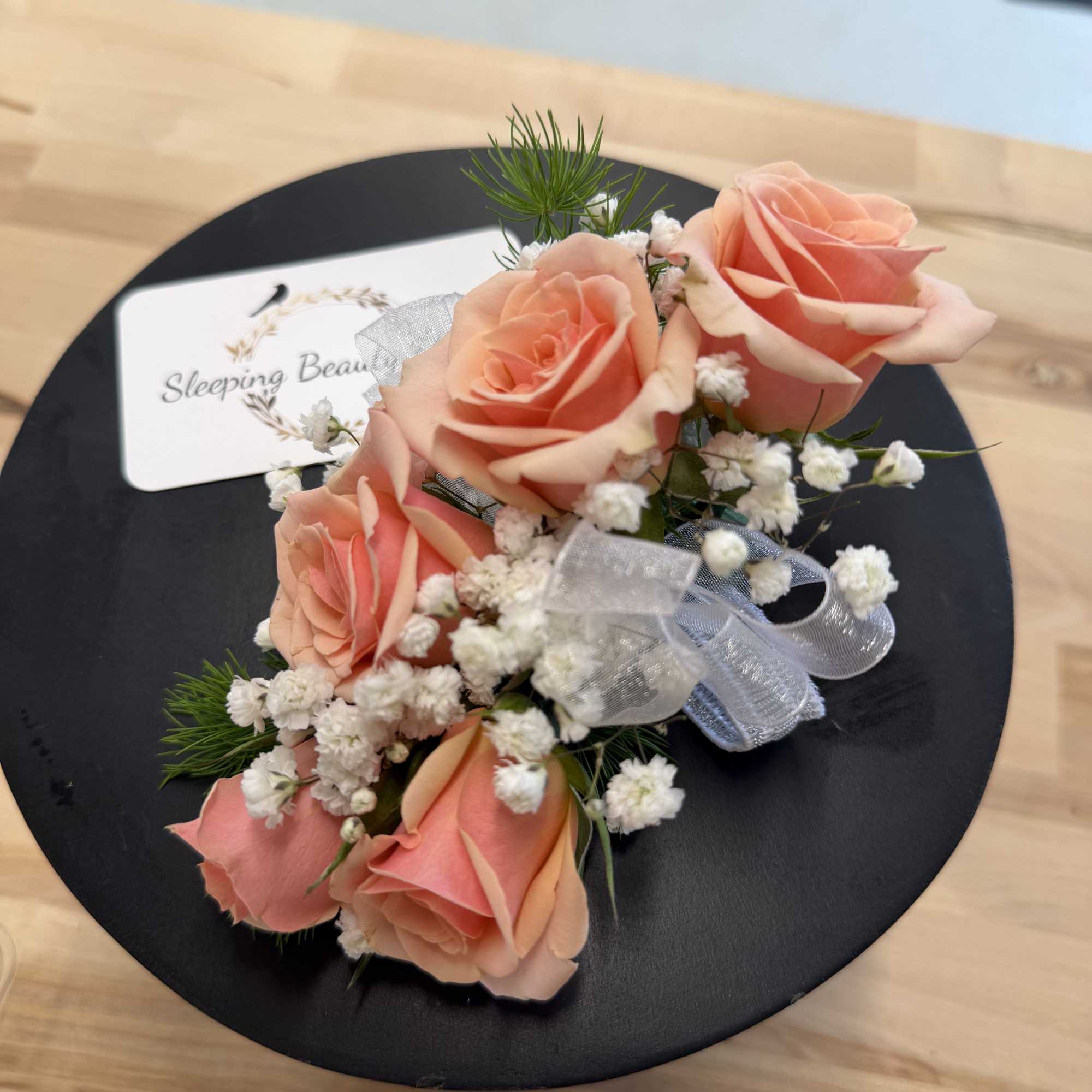 A classic white corsage with silver sheer ribbon, this wrist arrangement looks