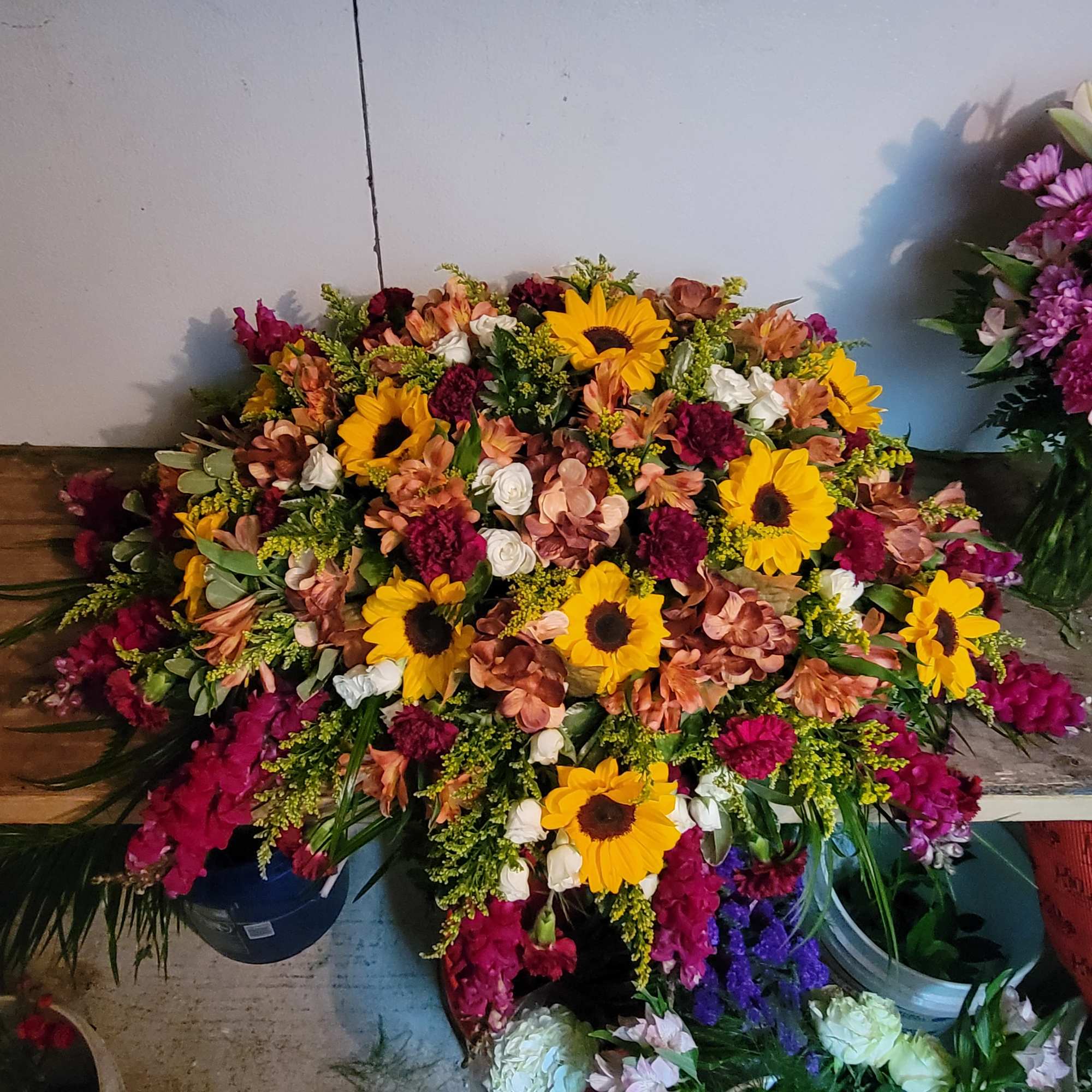 Large mixed flower arrangement with sunflowers, roses, and carnations
