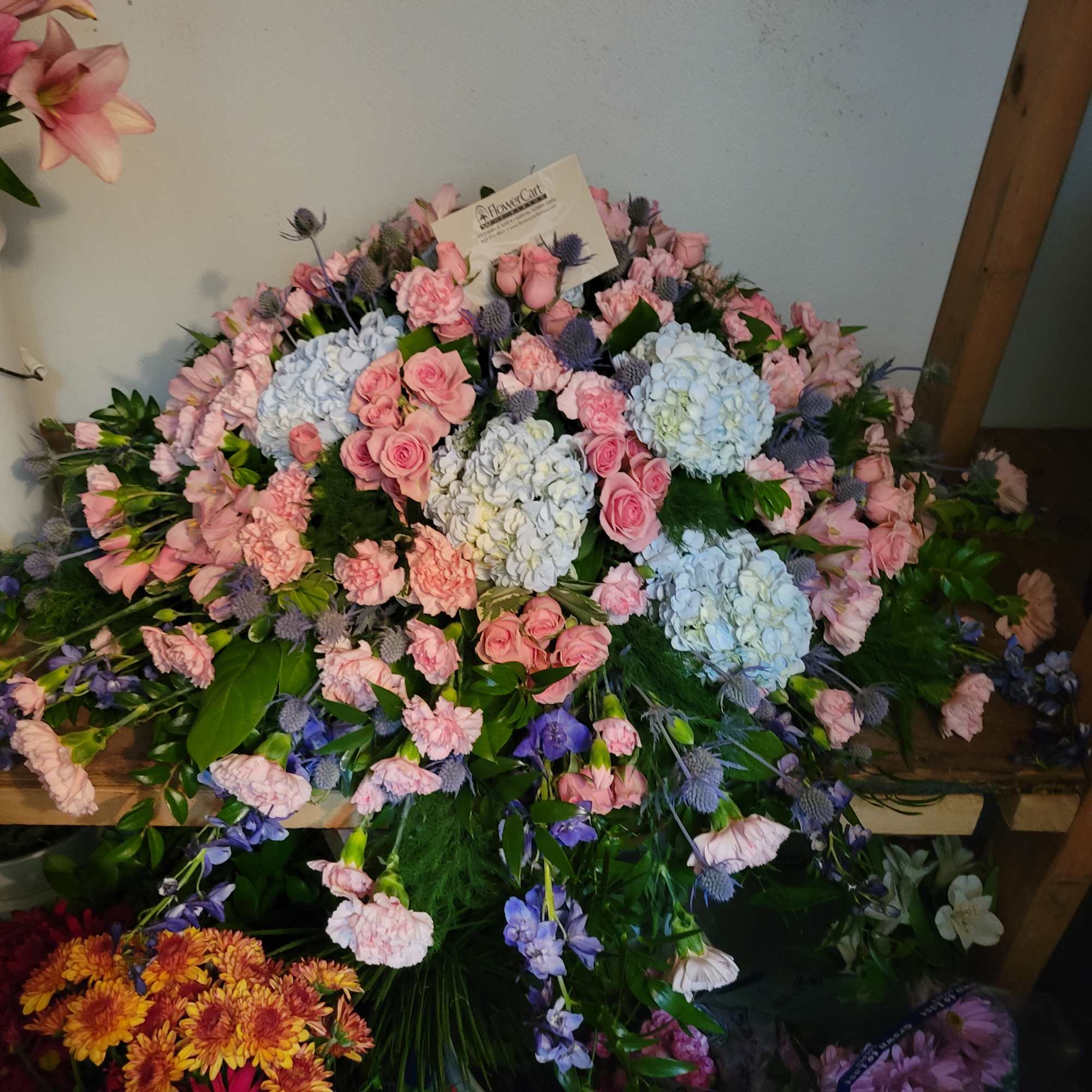 Large pastel floral spray with pink roses, hydrangeas, and carnations