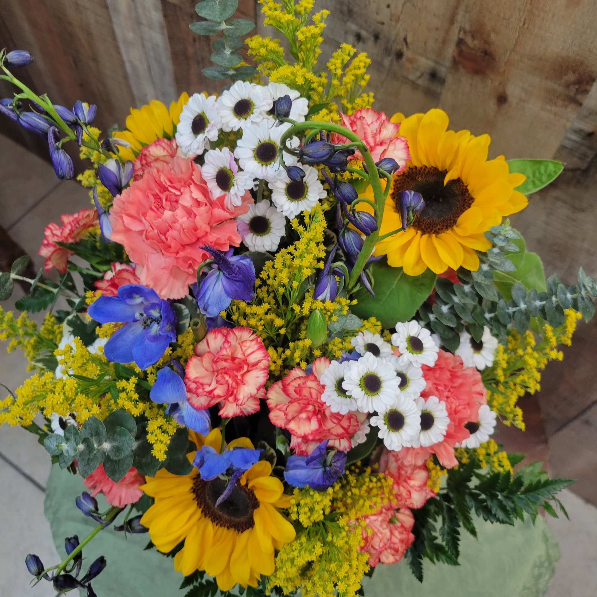 Mixed bouquet with sunflowers, carnations, and small white daisies