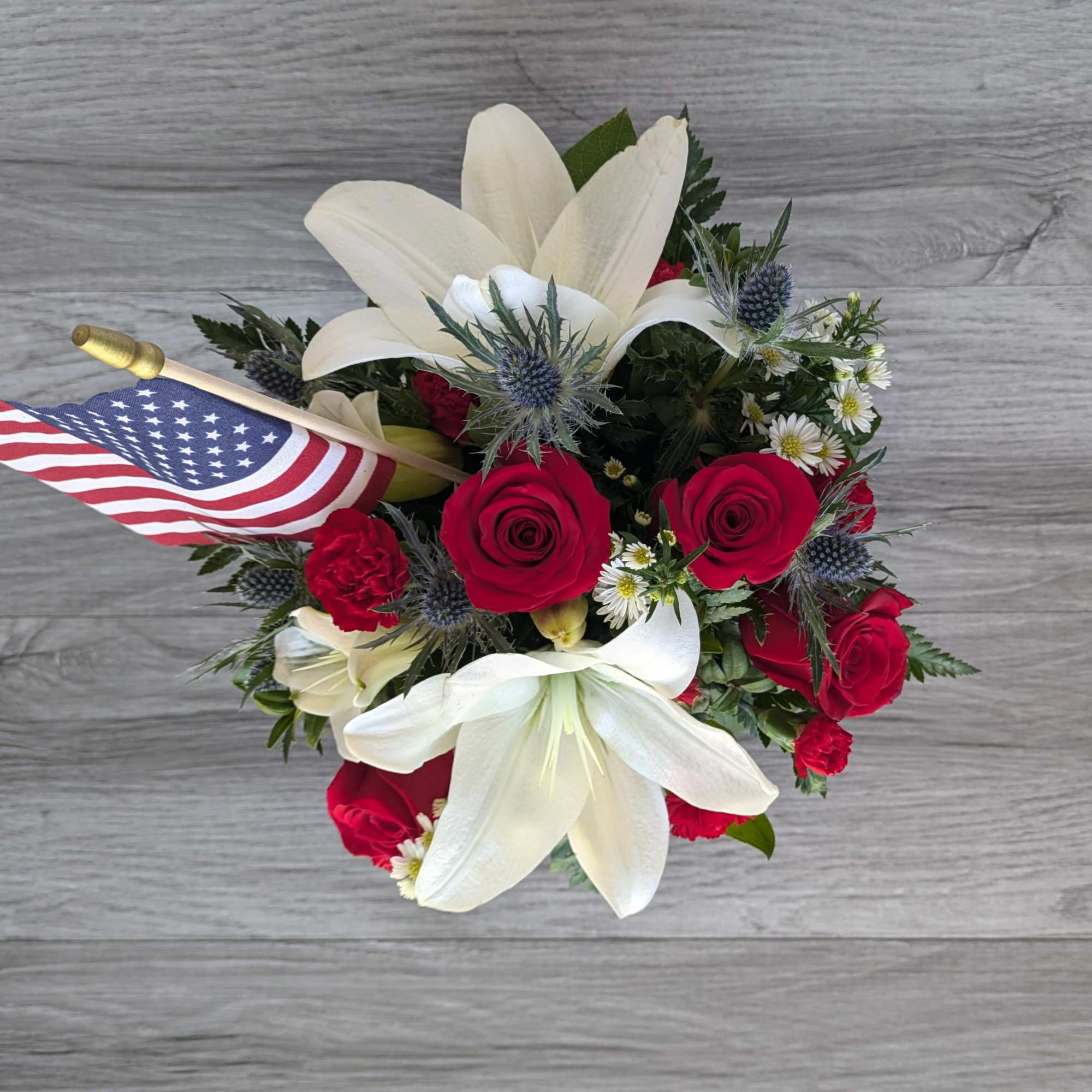 Bouquet of red roses and white lilies with a small American flag
