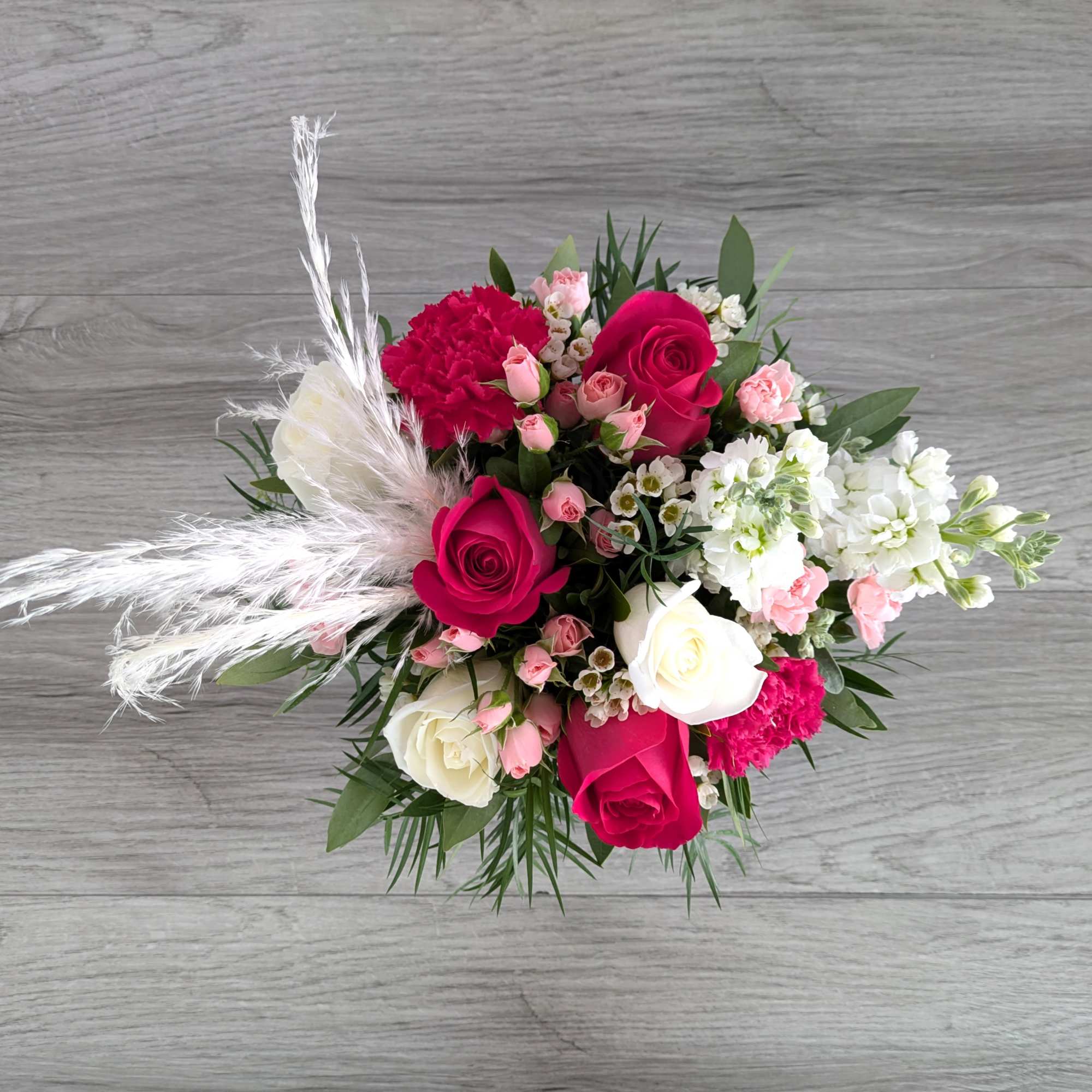 Bouquet of pink and white roses with carnations and white feathers