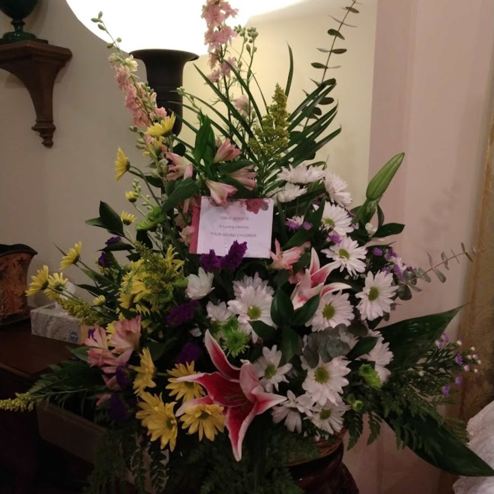 Tall mixed floral spray with lilies and daisies in a vase