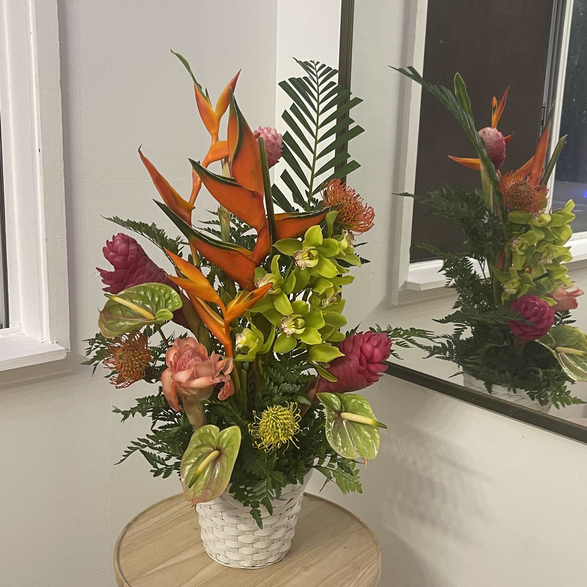 A large beautiful display of tropical flowers in a basket  of