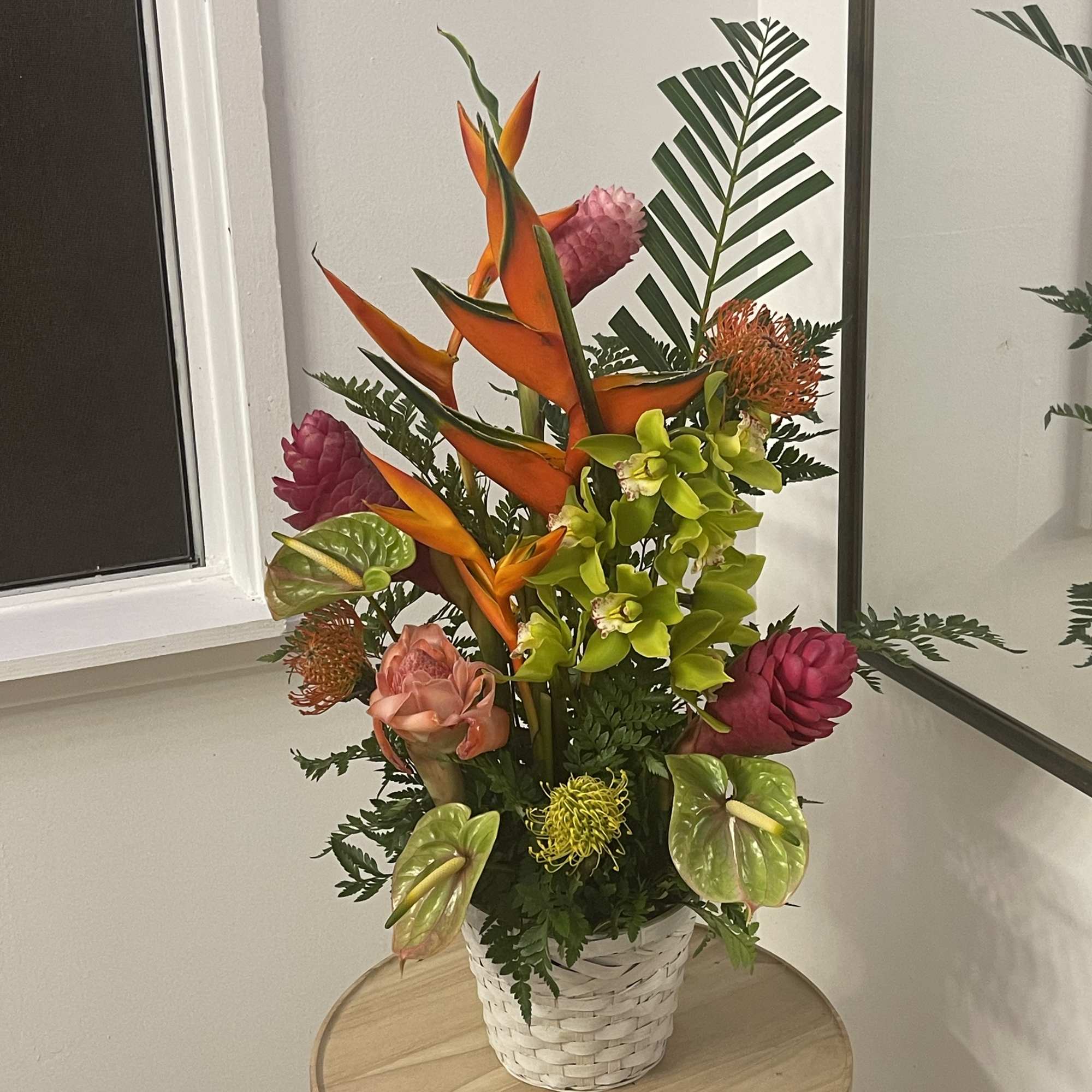 A large beautiful display of tropical flowers in a basket  of